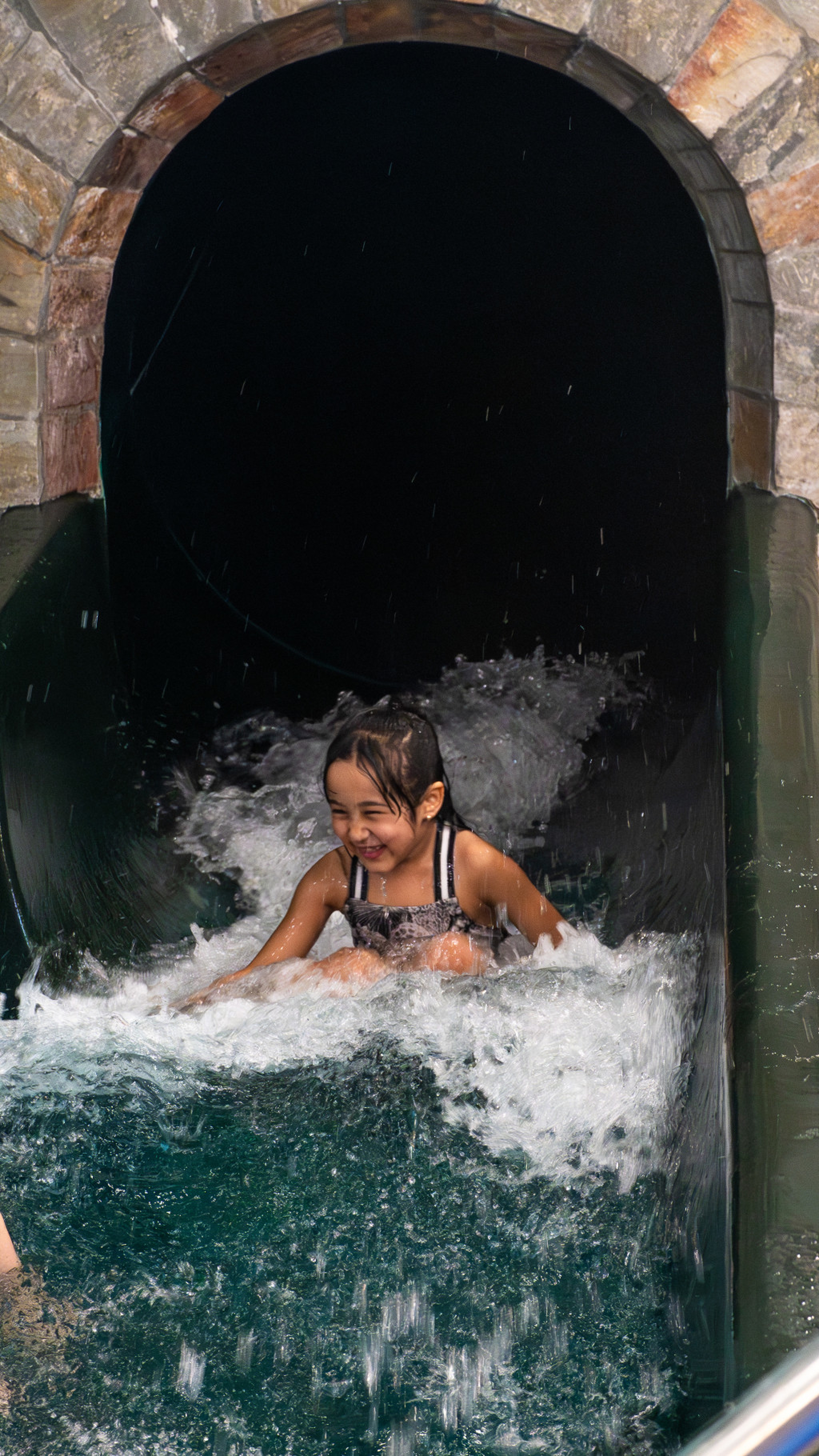 Meisje gaat van de glijbaan bij Vakantiepark Dierenbos