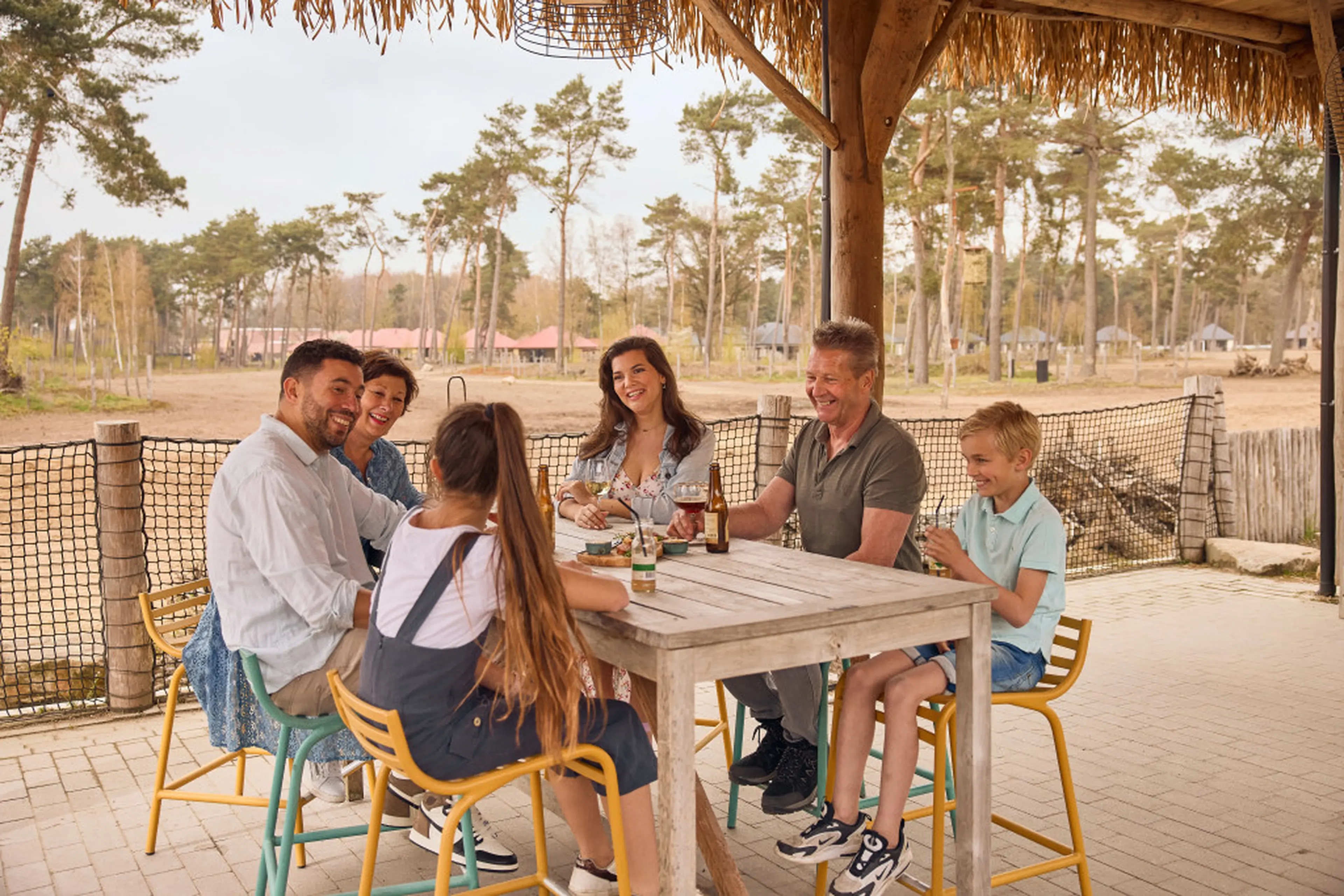 Gezin aan het borrelen op het terras aan de savanne van Safari Resort Beekse Bergen