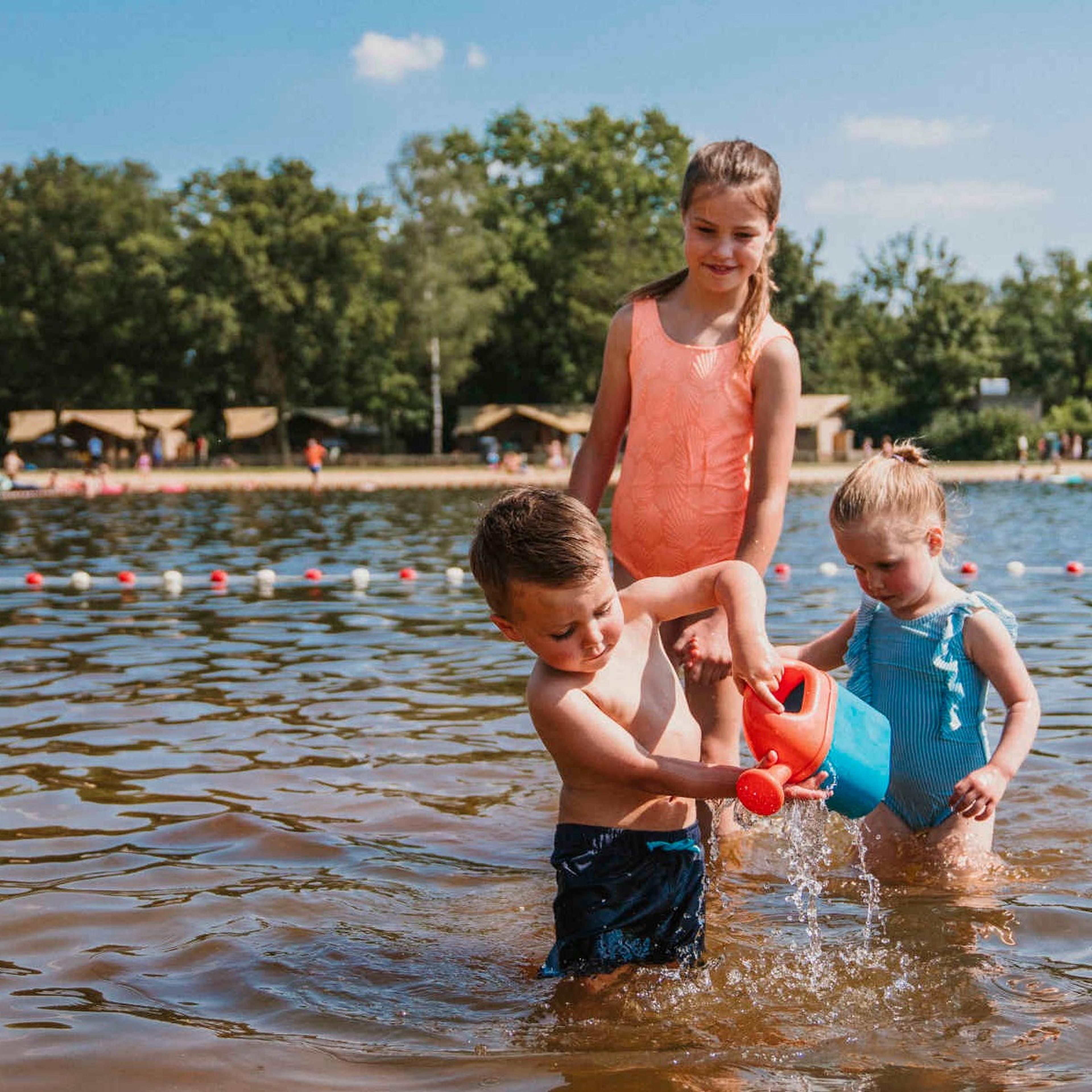 Drie kinderen spelen in de zwemvijver bij Vakantiepark Dierenbos.
