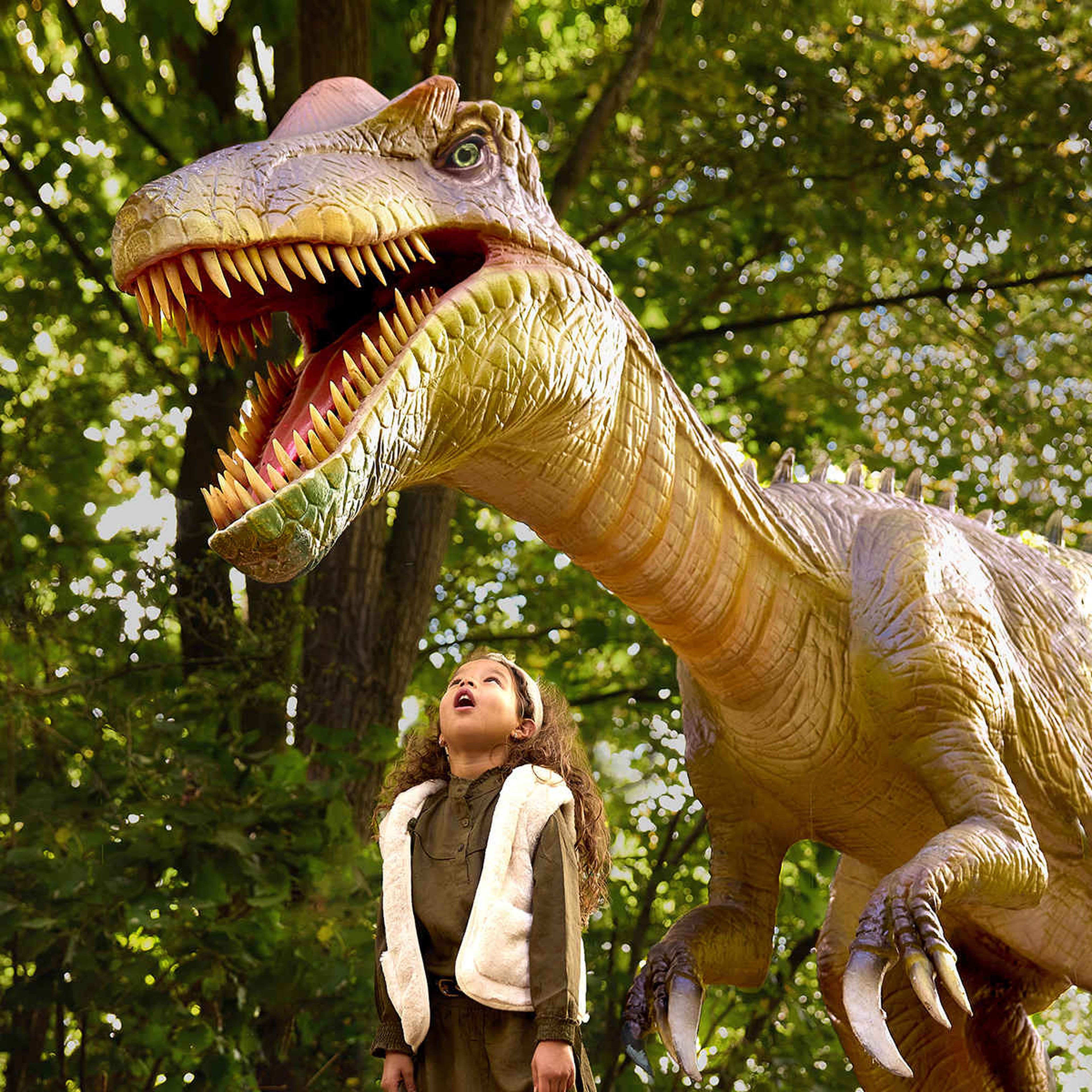 Een meisje staat te kijiken naar een dino bij DINO vs DIER bij Eindhoven Zoo.