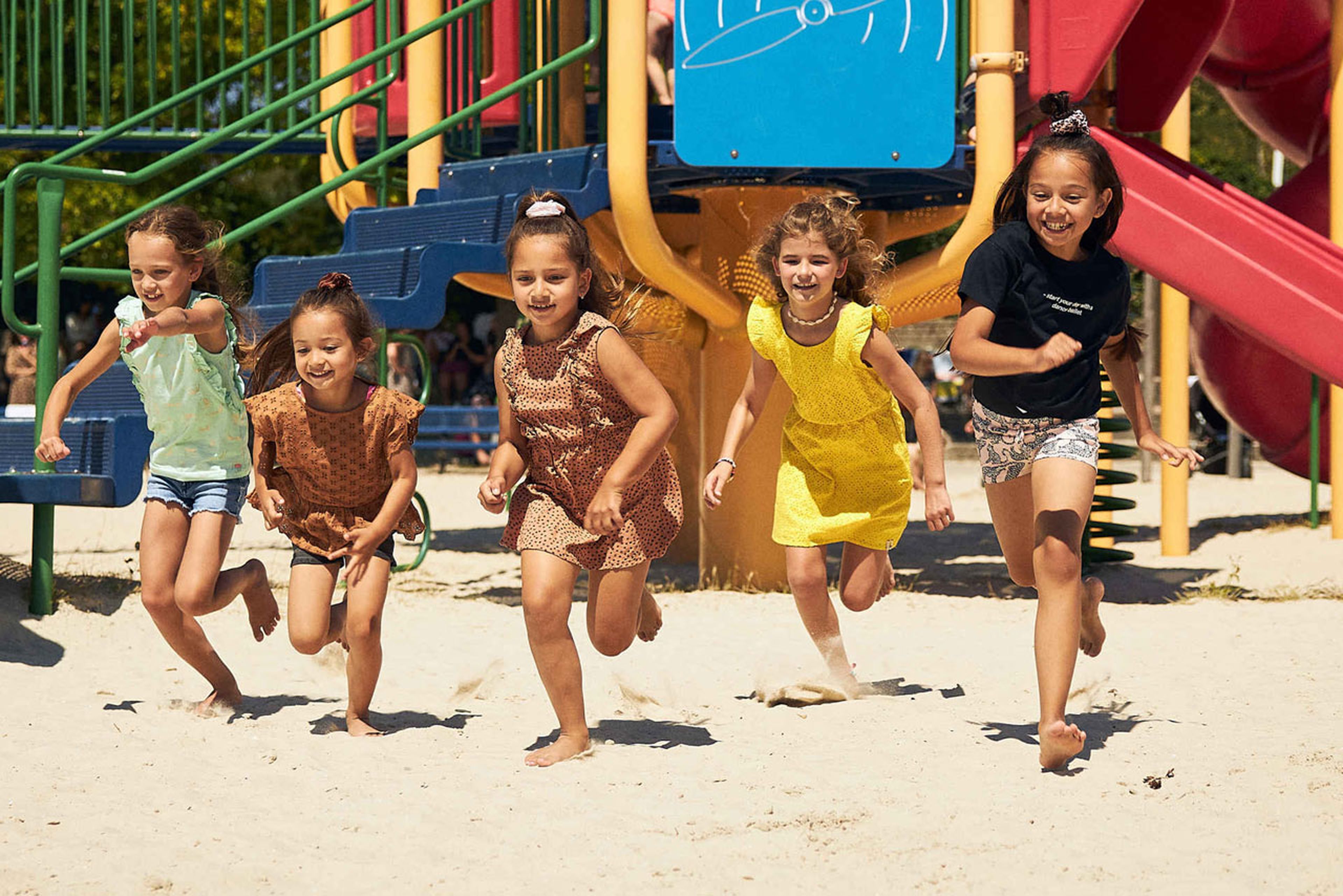 Vijf rennende kinderen op het strand van speelland Beekse Bergen