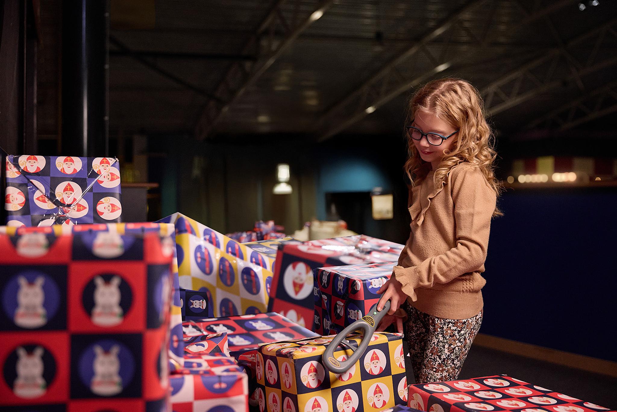 Een meisje scant pakjes tijdens SintAIRklaas bij Luchtvaartmuseum Aviodrome