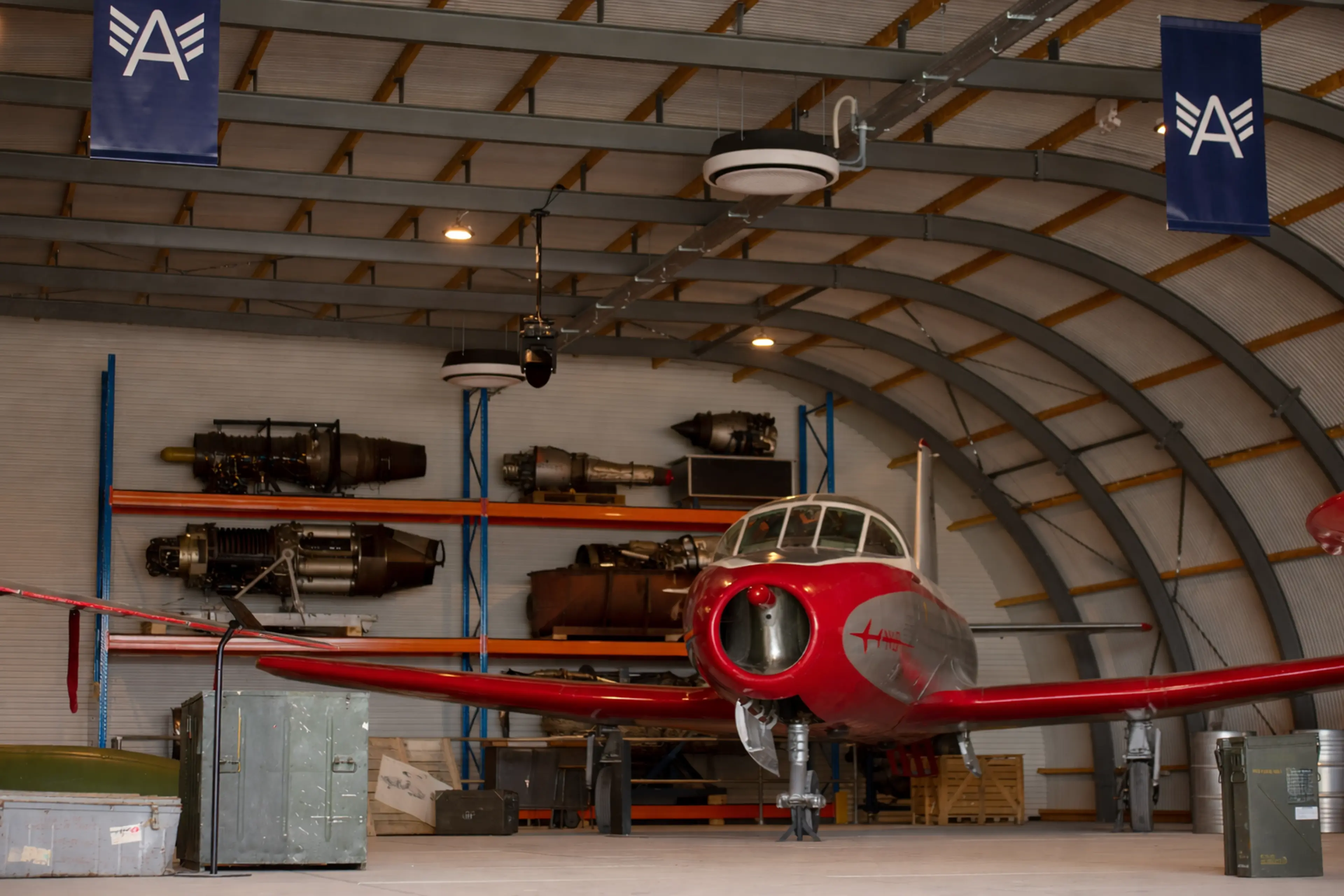 Een vintage rode jet in de hangar bij Aviodrome