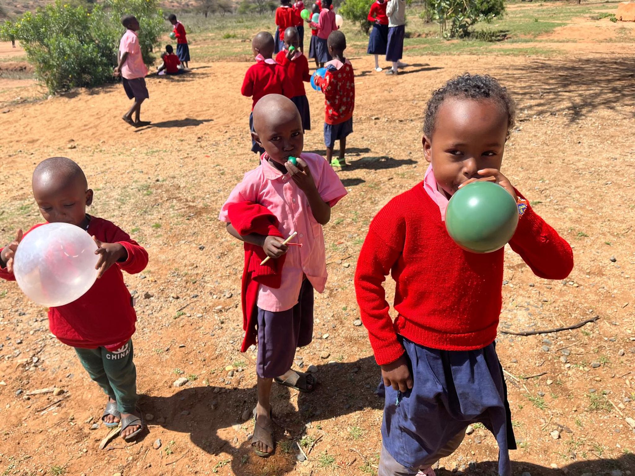 Schoolkinderen blazen ballonnen op bij een school in Kenia.