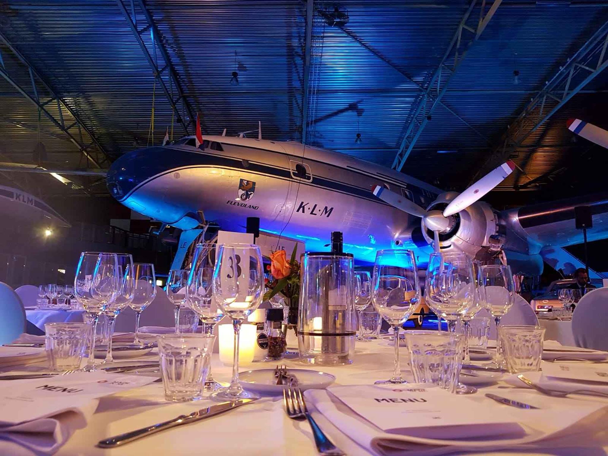Een opgedekte tafel voor een diner in de museumzaal van Luchtvaartmuseum Aviodrome