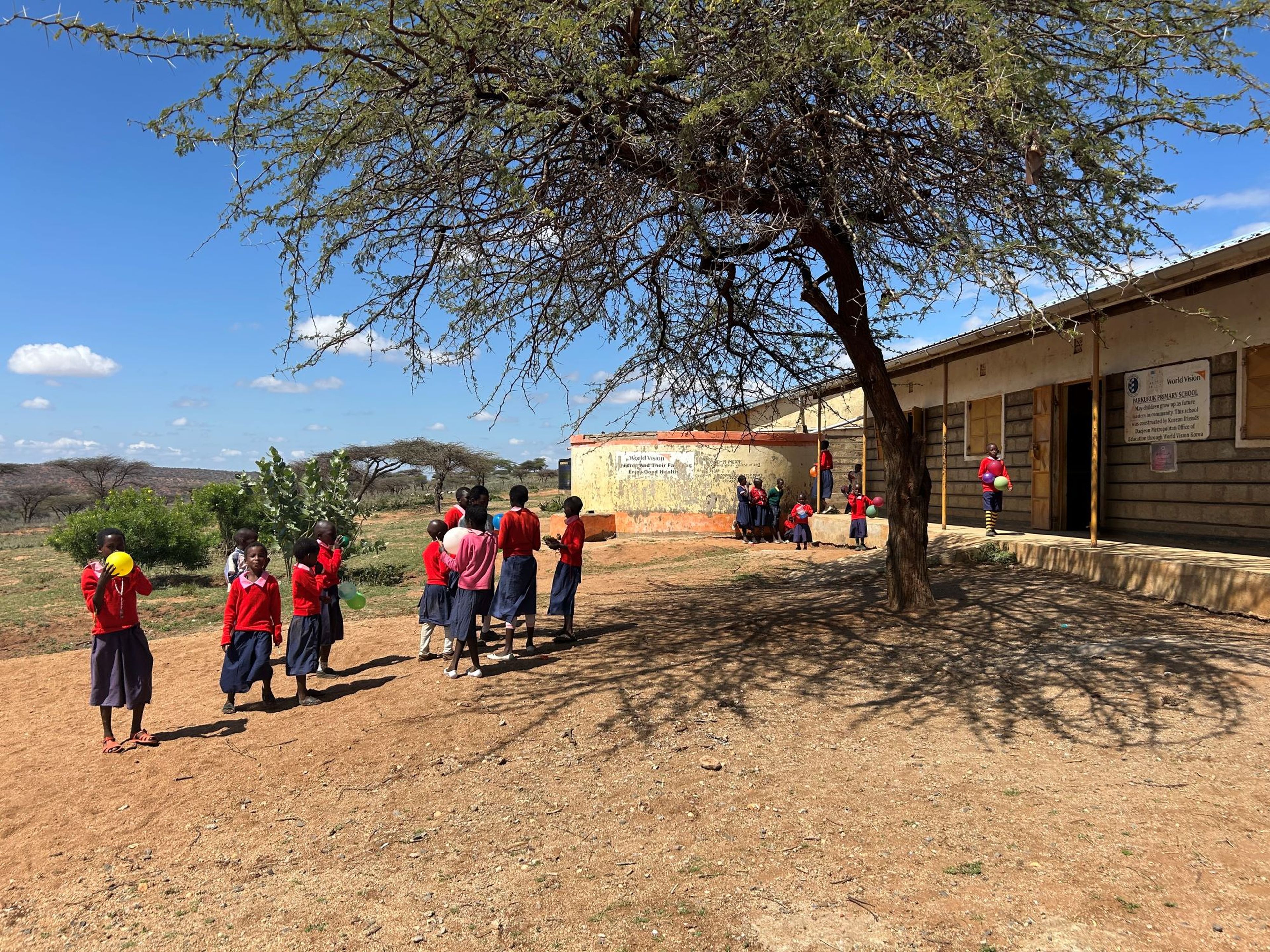 De schoolkinderen spelen buiten met ballonnen in Kenia.