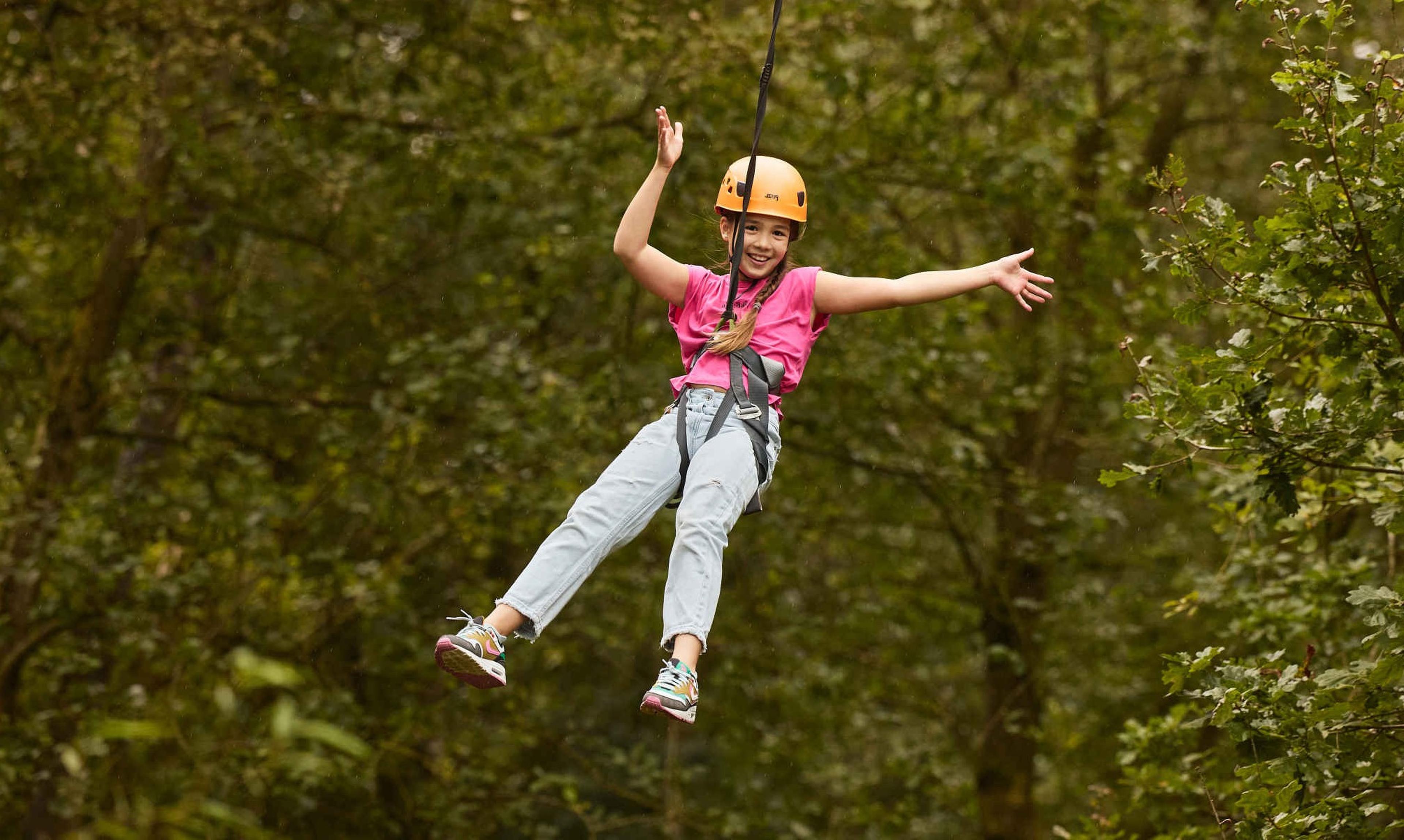 Een meisje gaat van de zipline op het klimparcours bij Klimrijk Brabant.