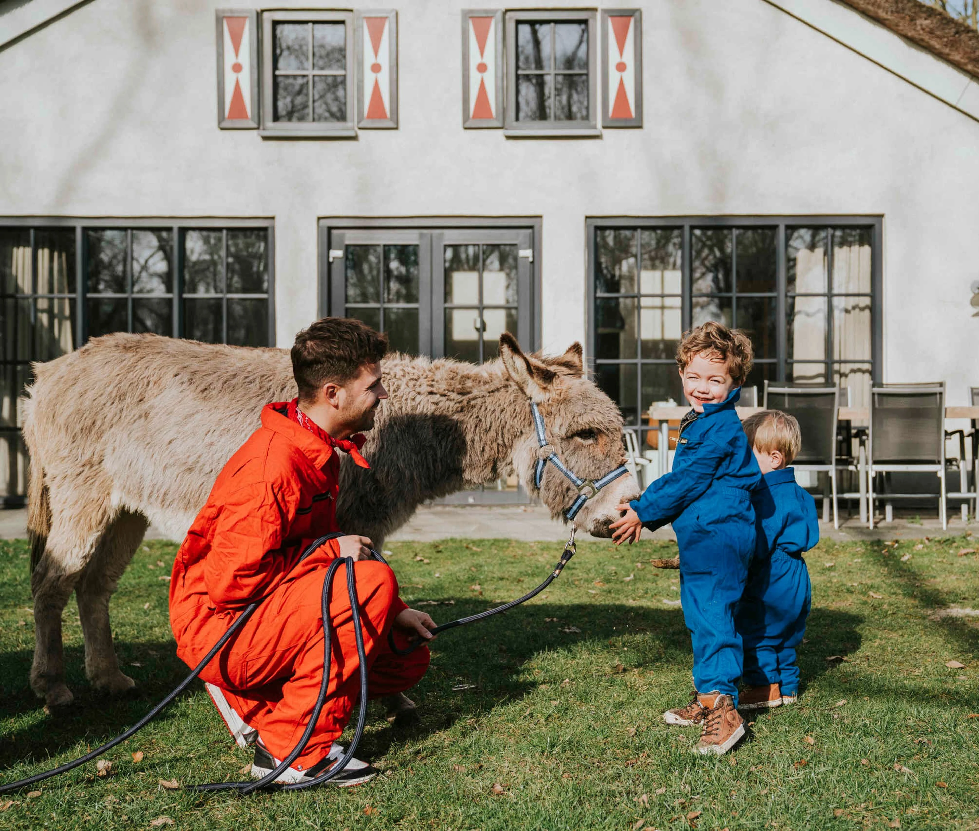 Een dierenverzorger met twee kinderen en een ezel bij Vakantiepark Dierenbos.