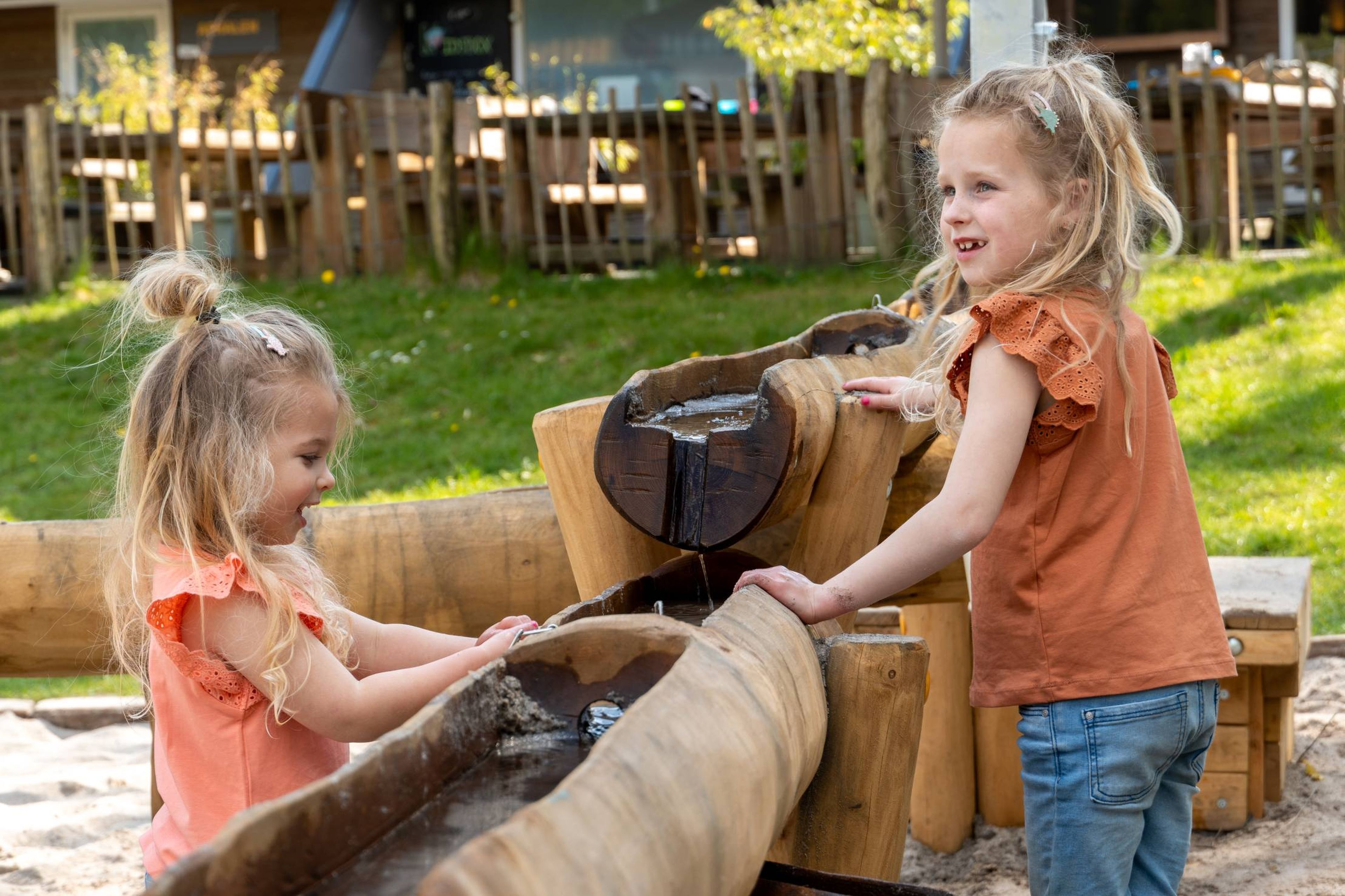 Meisjes spelen met water in de waterspeeltuin bij Klimrijk Brabant