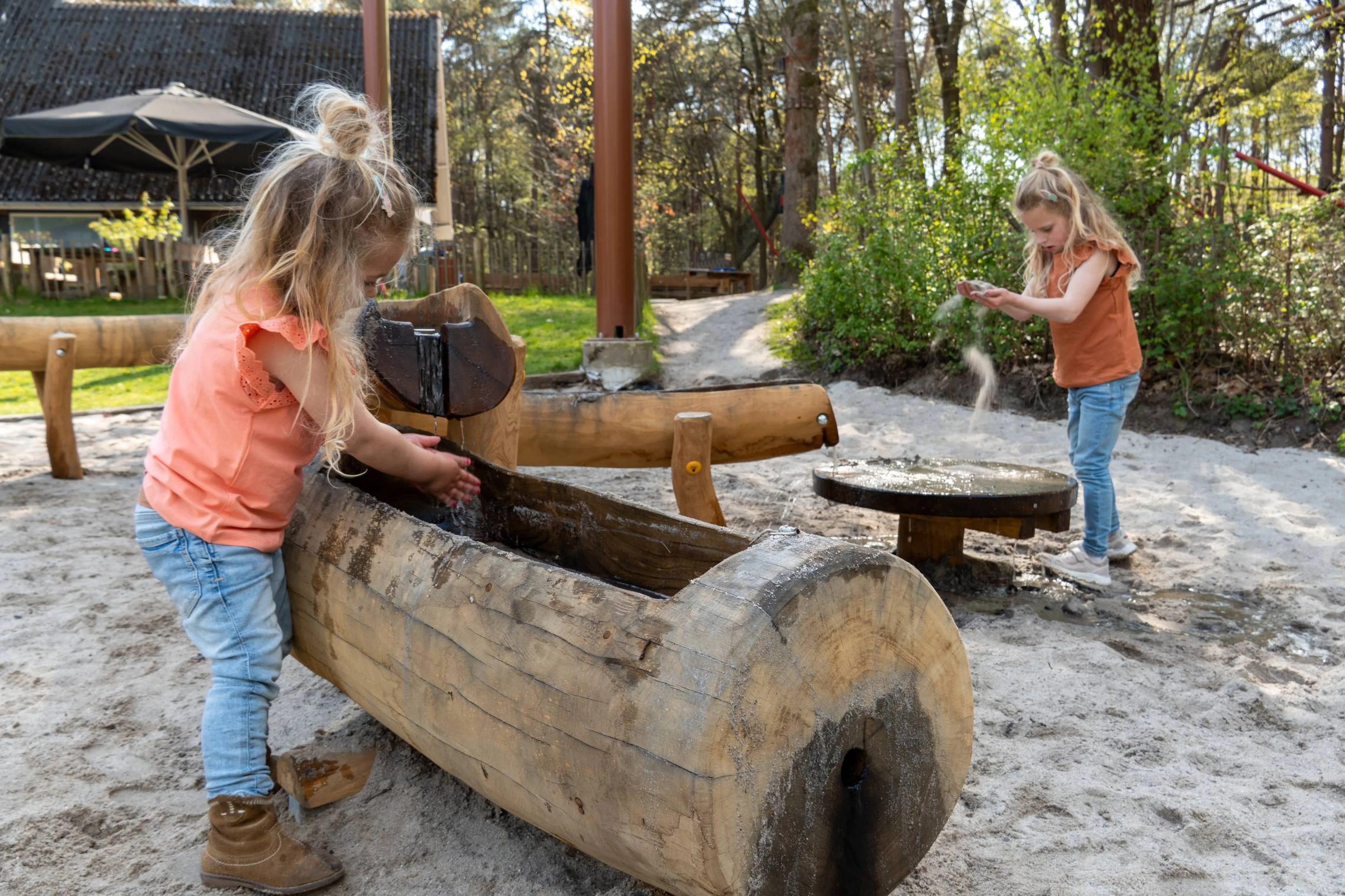 Meisjes spelen met water en zand in de waterspeeltuin bij Klimrijk Brabant