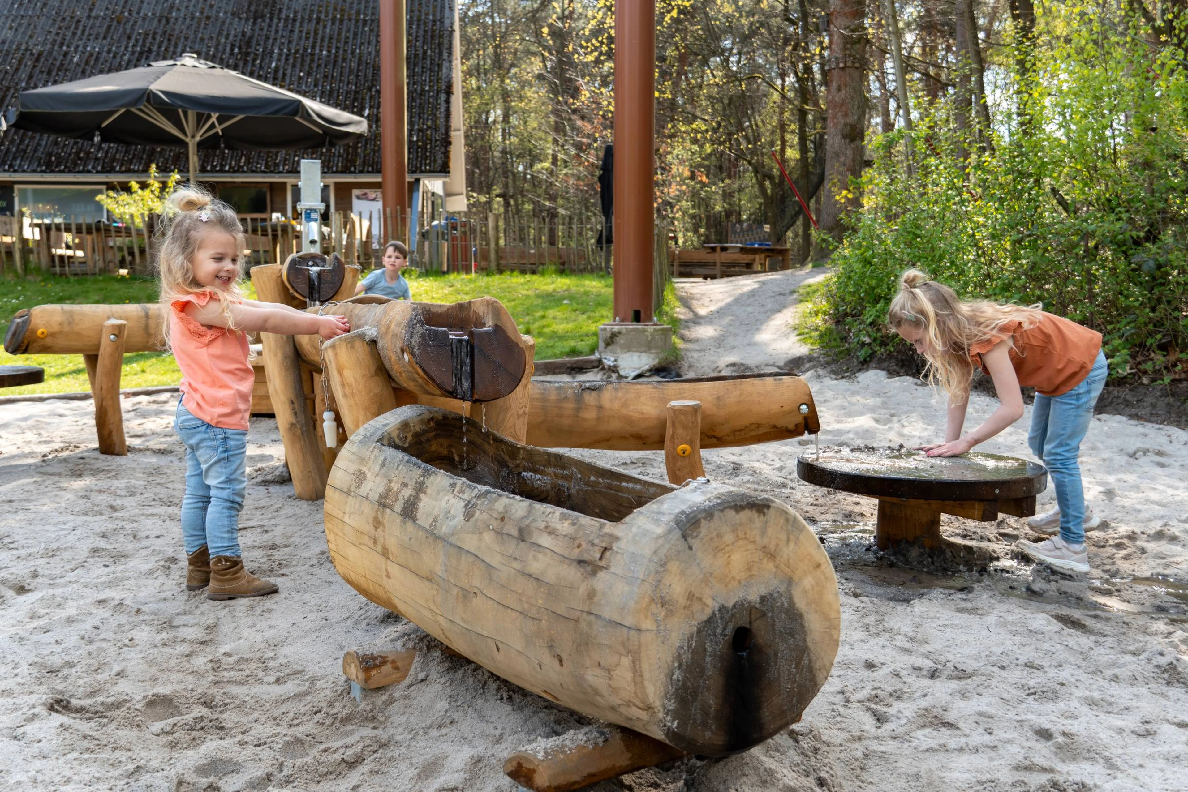 Meisjes spelen met water en zand in de waterspeeltuin bij Klimrijk Brabant