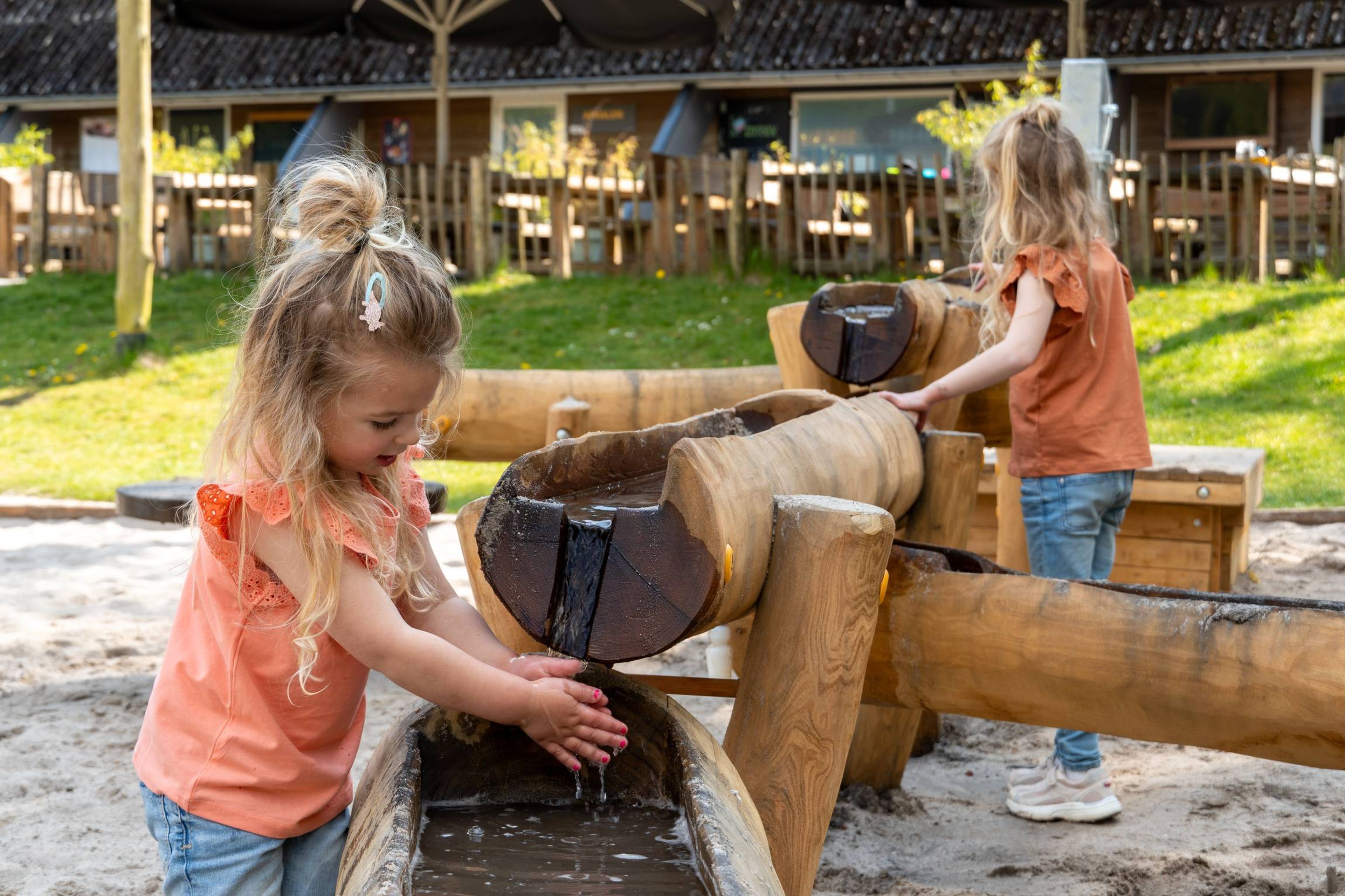 Meisjes spelen met water in de waterspeeltuin bij Klimrijk Brabant