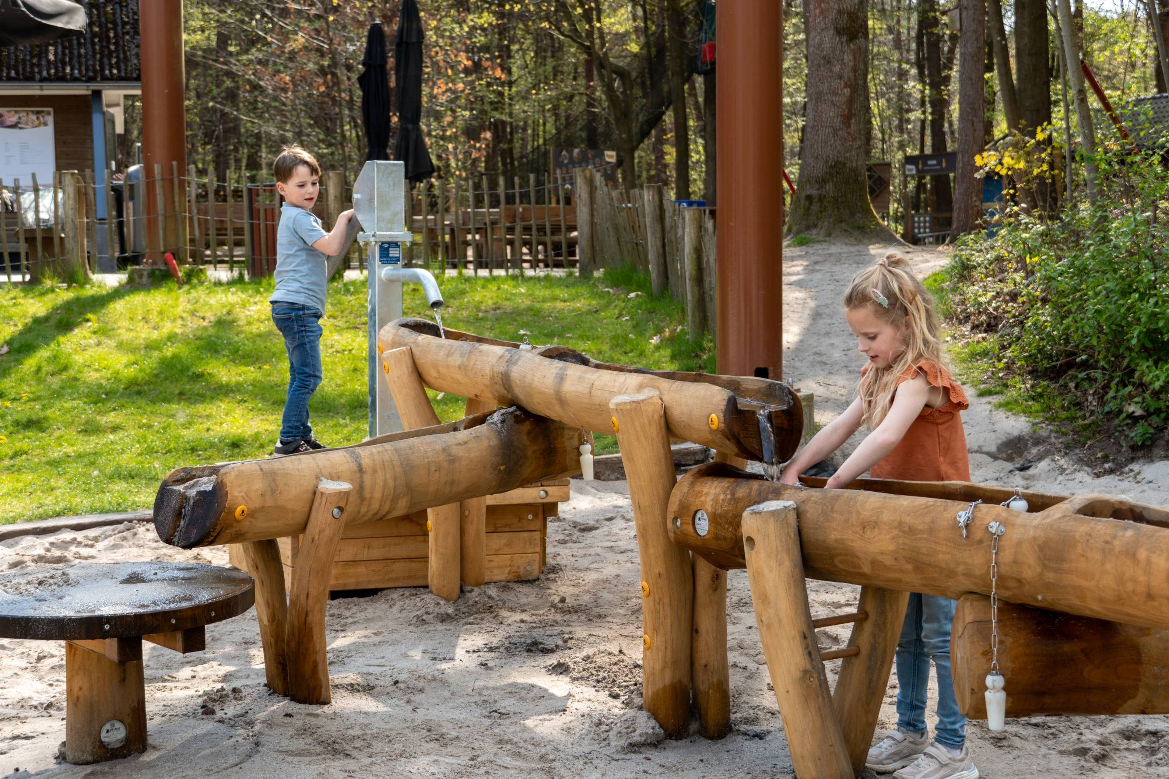 Een jongen en meisje spelen in de waterspeeltuin bij Klimrijk Brabant