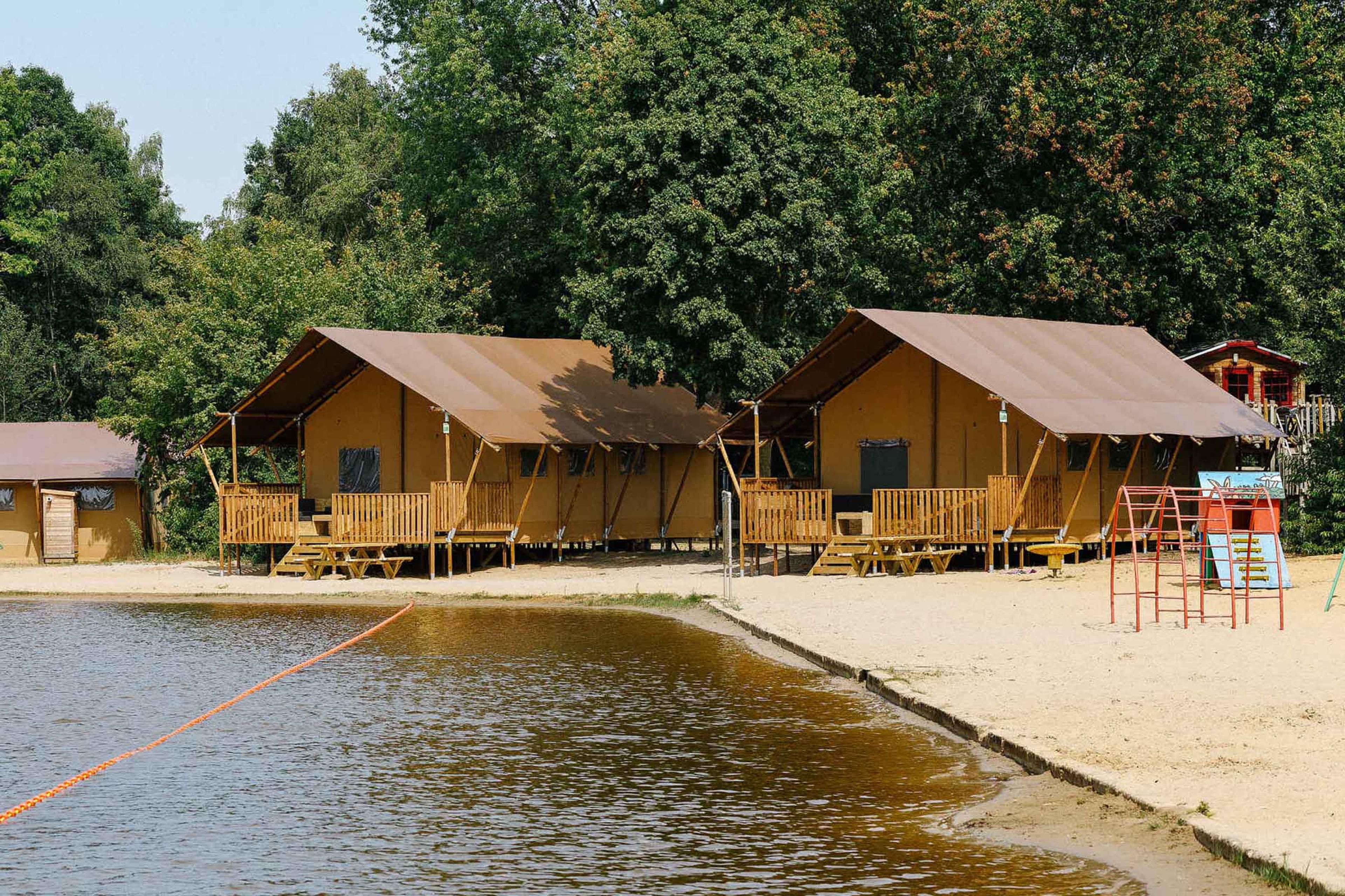 Zwemvijver met 2 Luxe Lodgetenten Pauw Plus op Vakantiepark Dierenbos