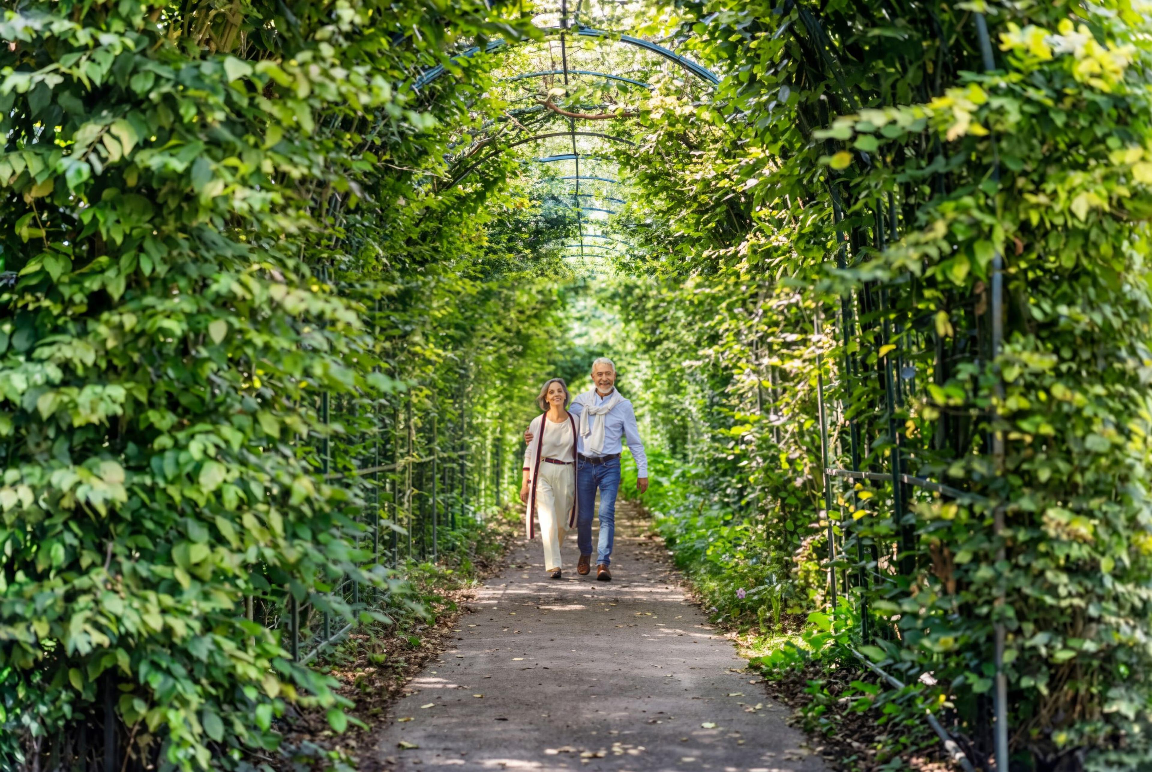 Twee personen wandelen in de tuin van Kasteel Steenenburg