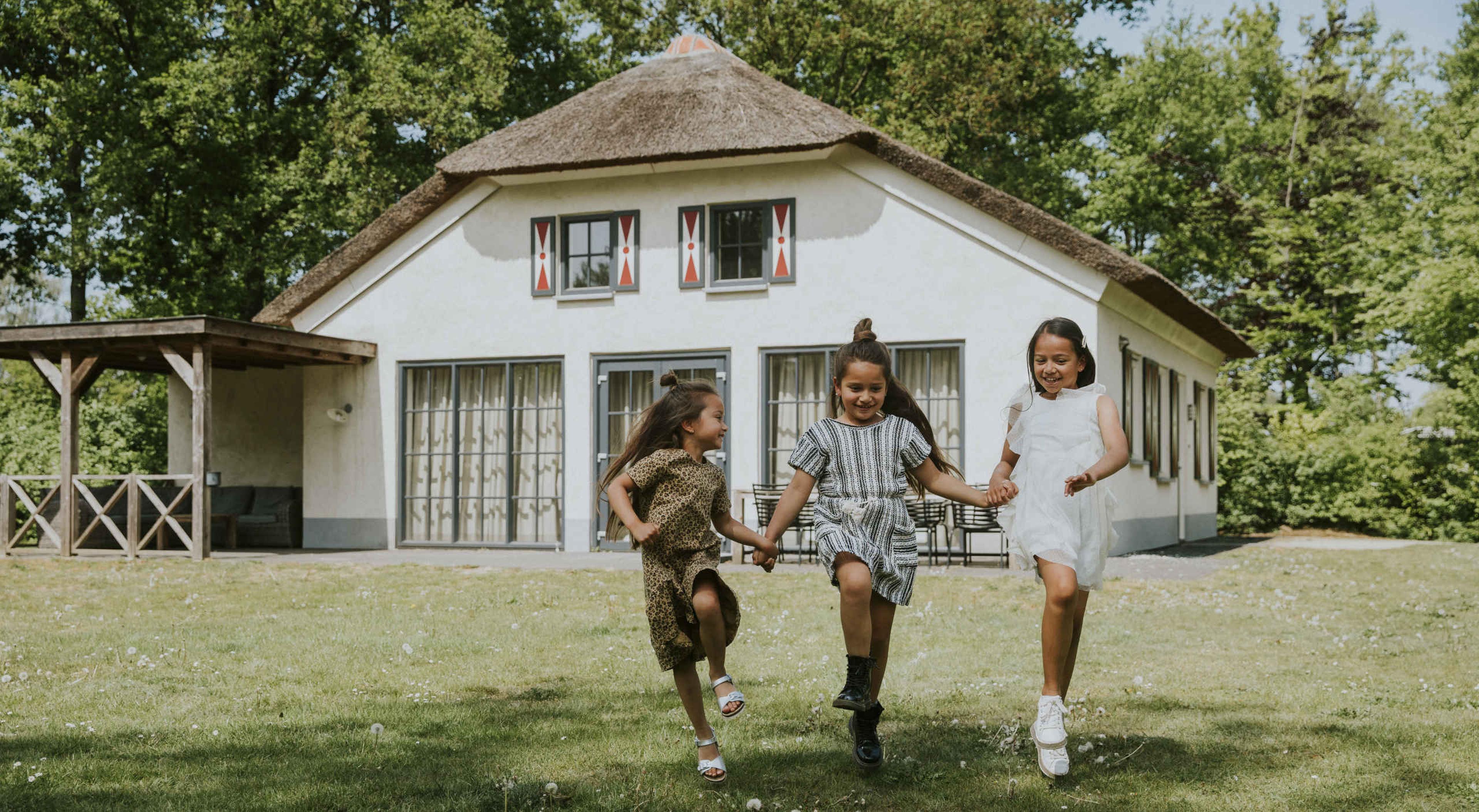 Meisjes rennen op het gras bij Villa Alpca op Vakantiepark Dierenbos