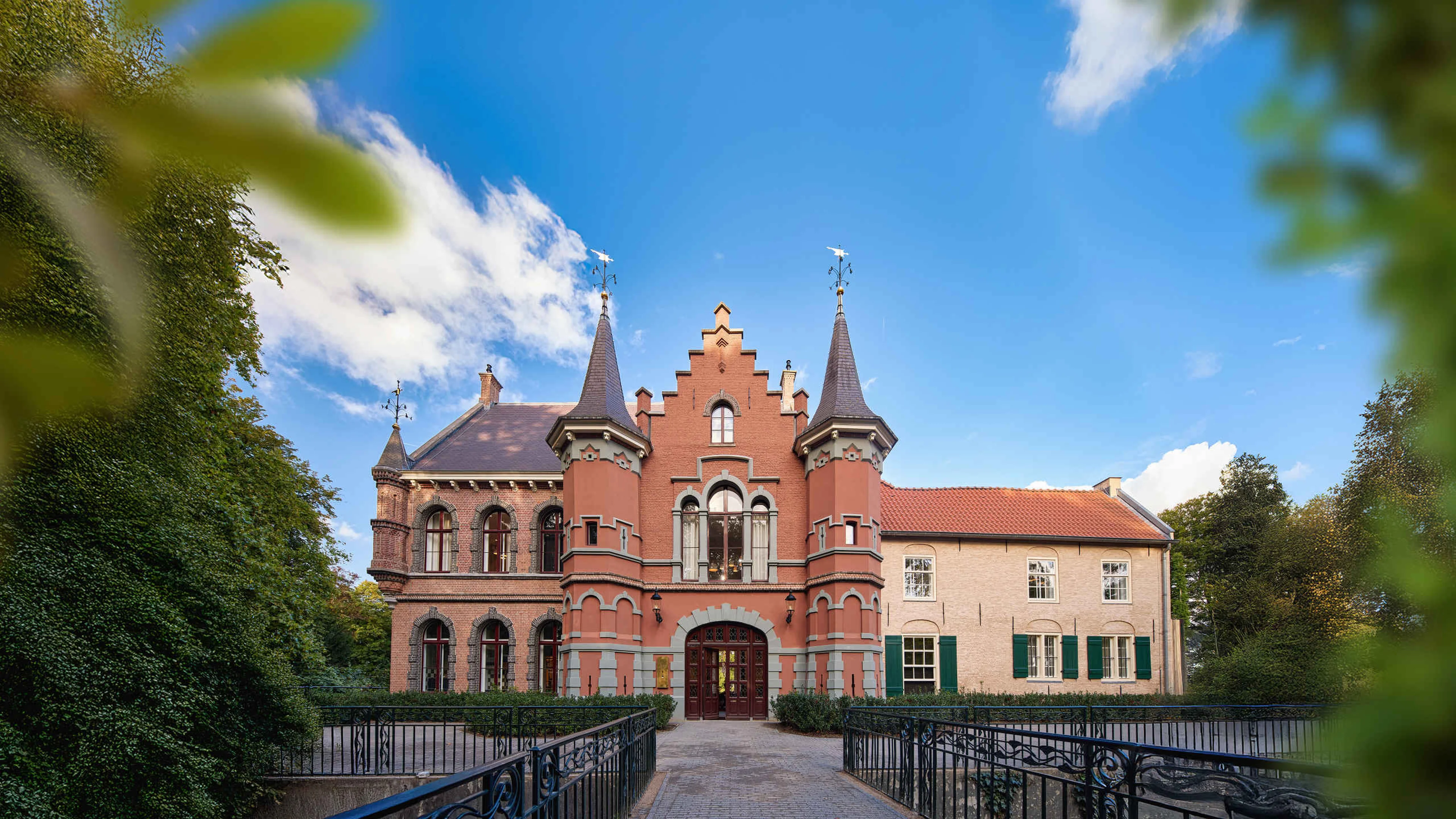 Aanzicht exterieur met groene bladeren van Kasteel Steenenburg