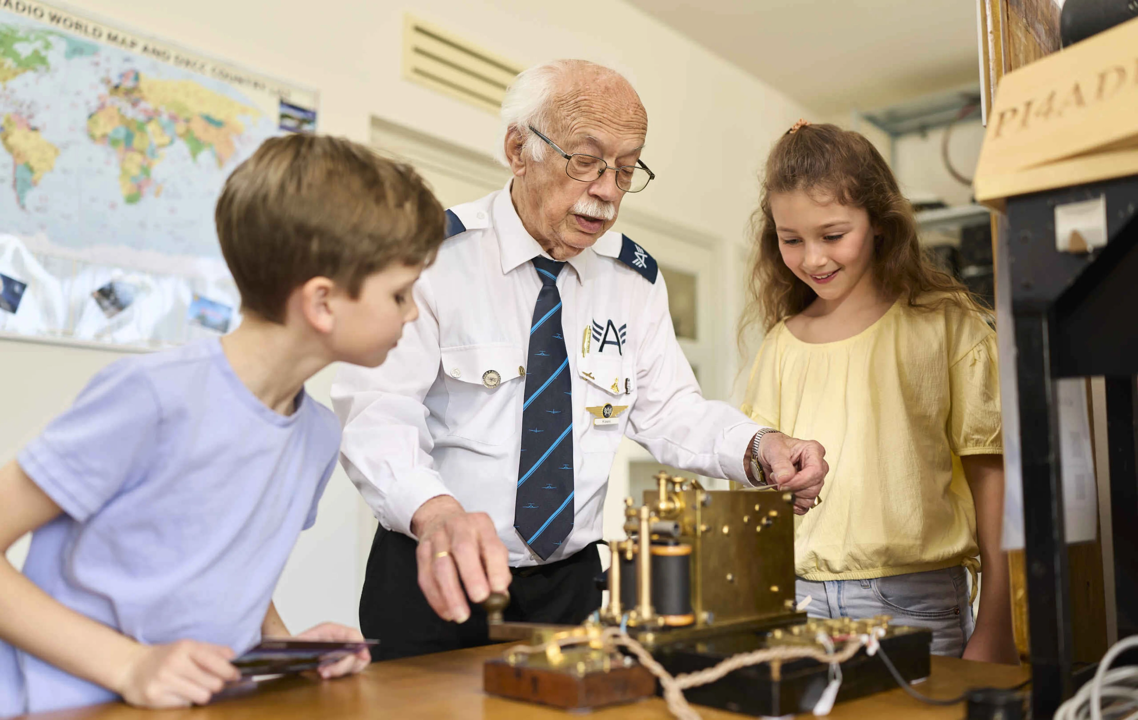 Kinderen leren morsecode van een vrijwilliger in de radiokamer van Luchtvaartmuseum Aviodrome