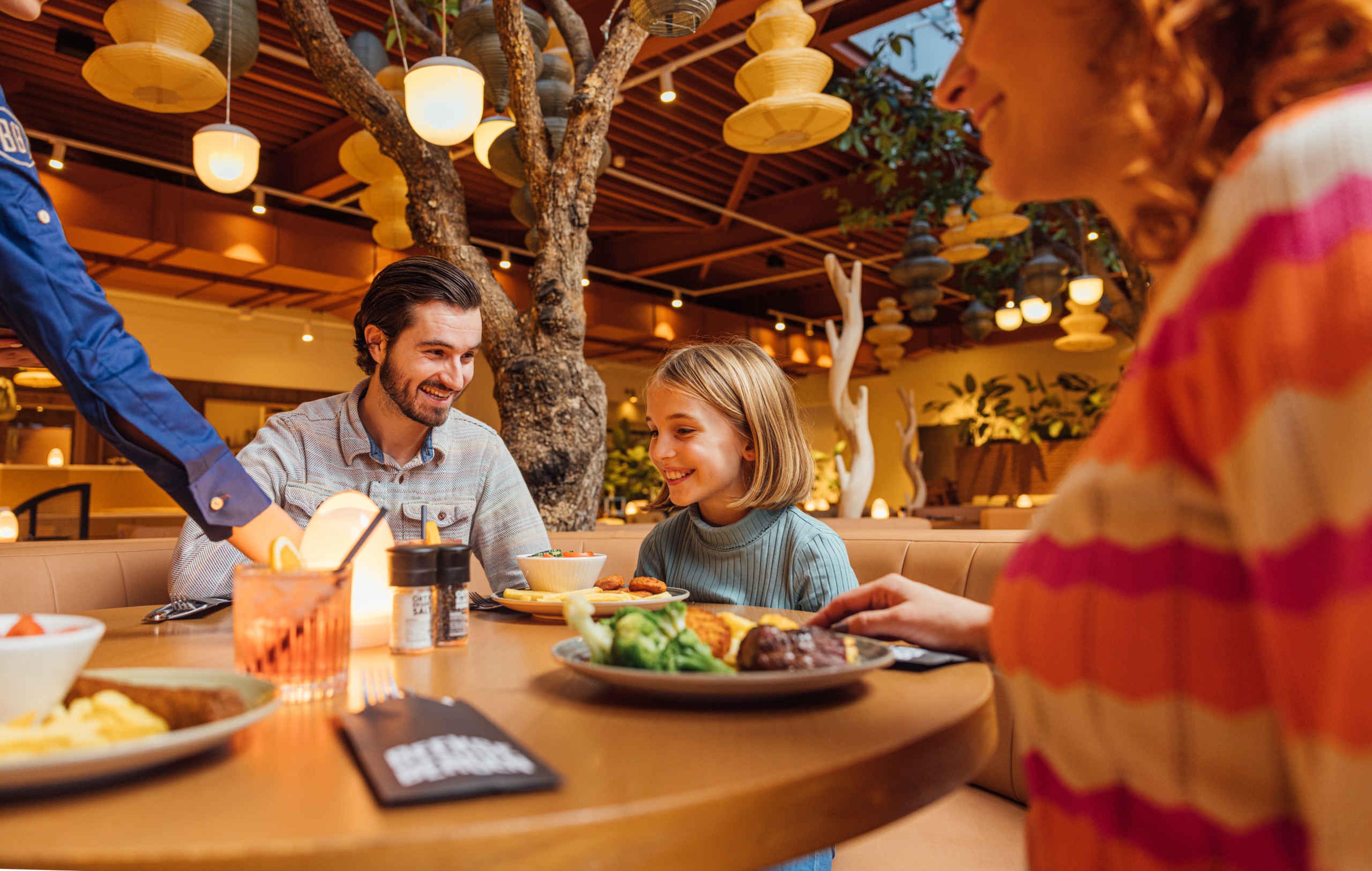 Een gezin zit te dineren bij buffet en live cooking restaurant Amma in Safari Hotel Beekse Bergen.