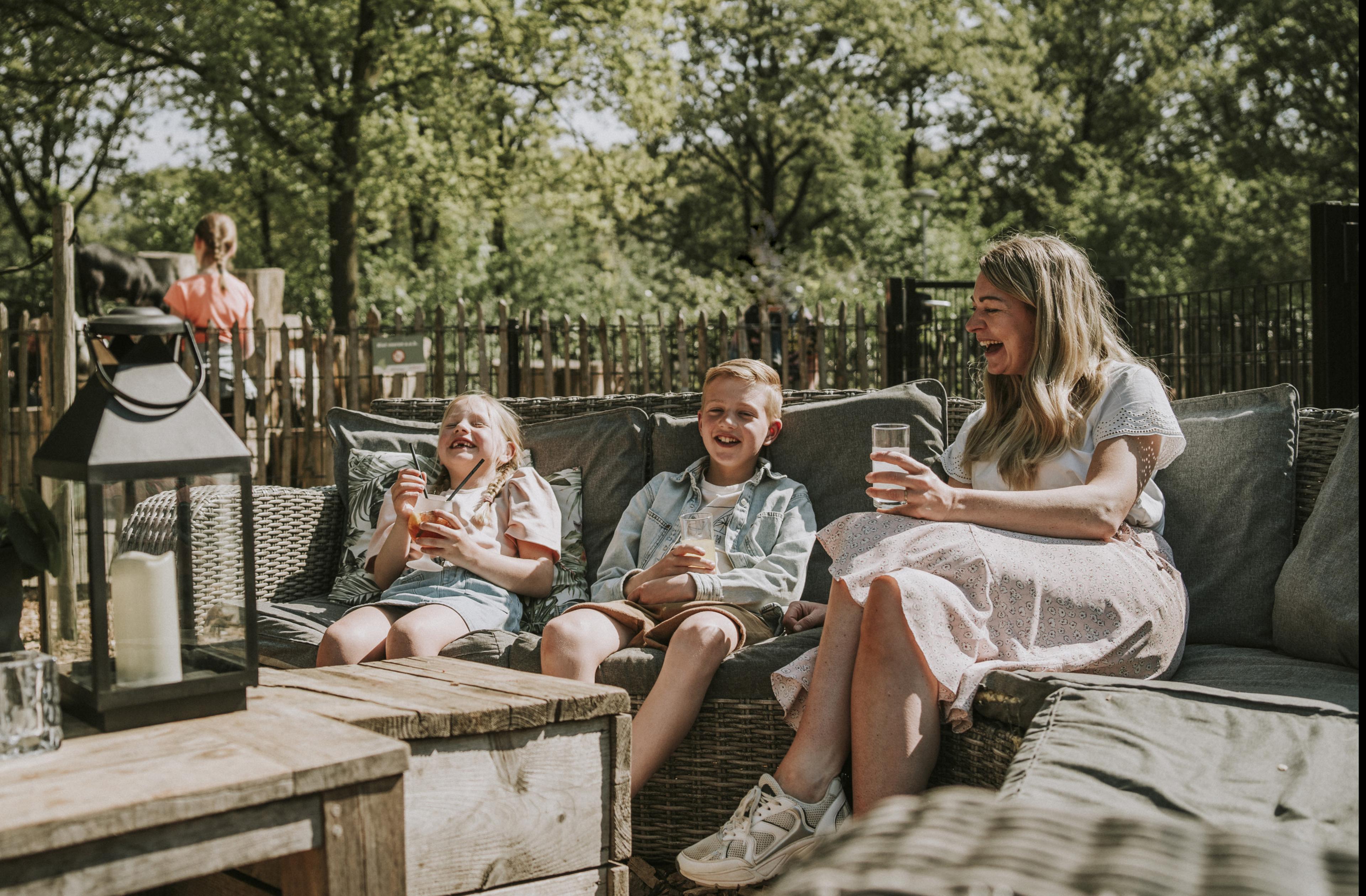 Moeder en kinderen met een drankje op het terras bij Vakantiepark Dierenbos