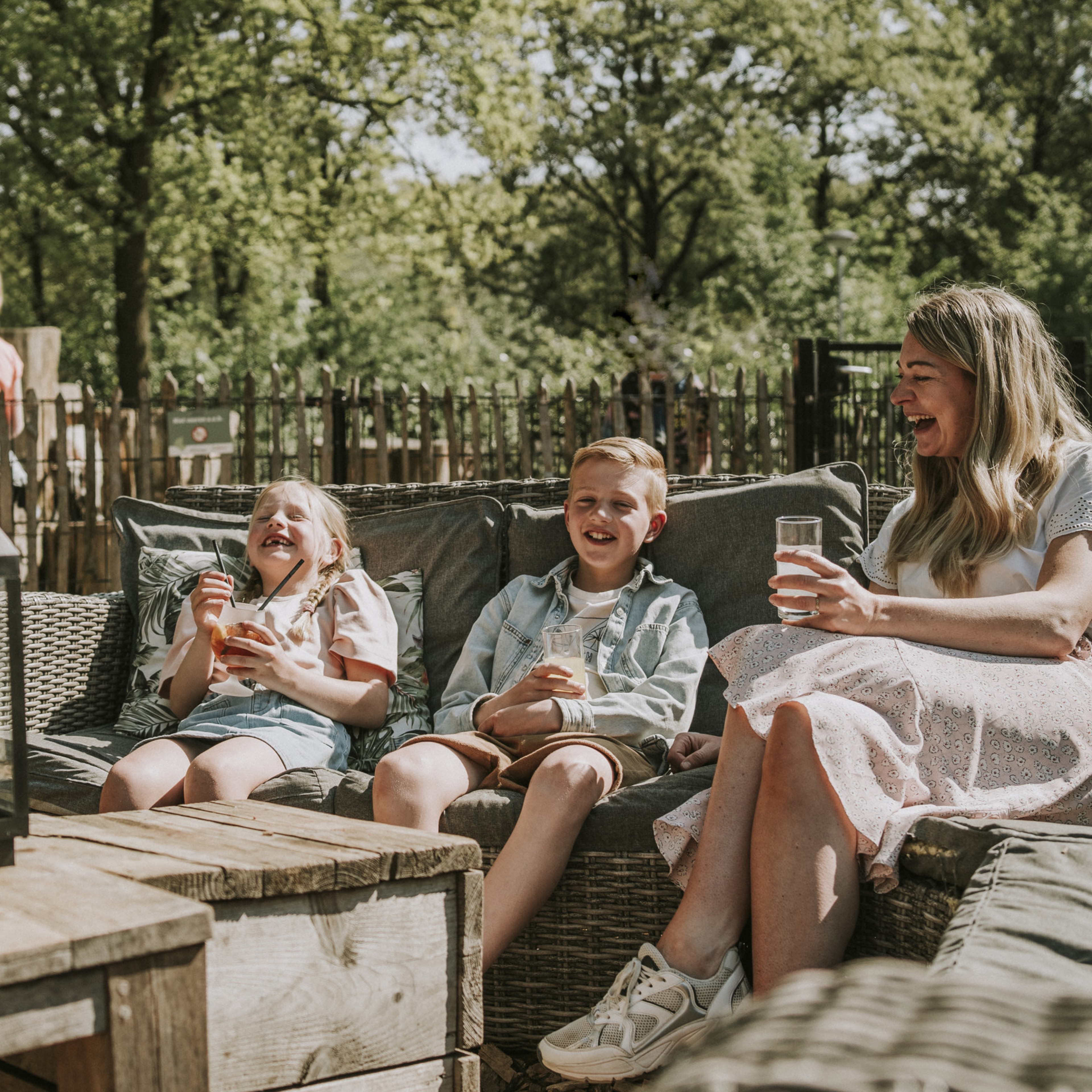 Moeder en kinderen met een drankje op het terras bij Vakantiepark Dierenbos