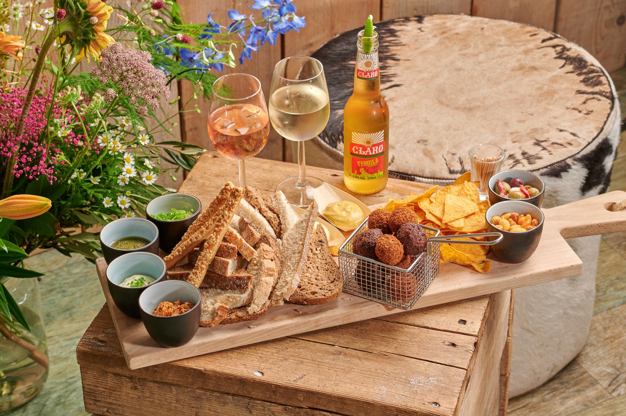 Borrelplank met broodjes en dips, bitterballen en nachos bij het restaurant van Vakantiepark Dierenbos