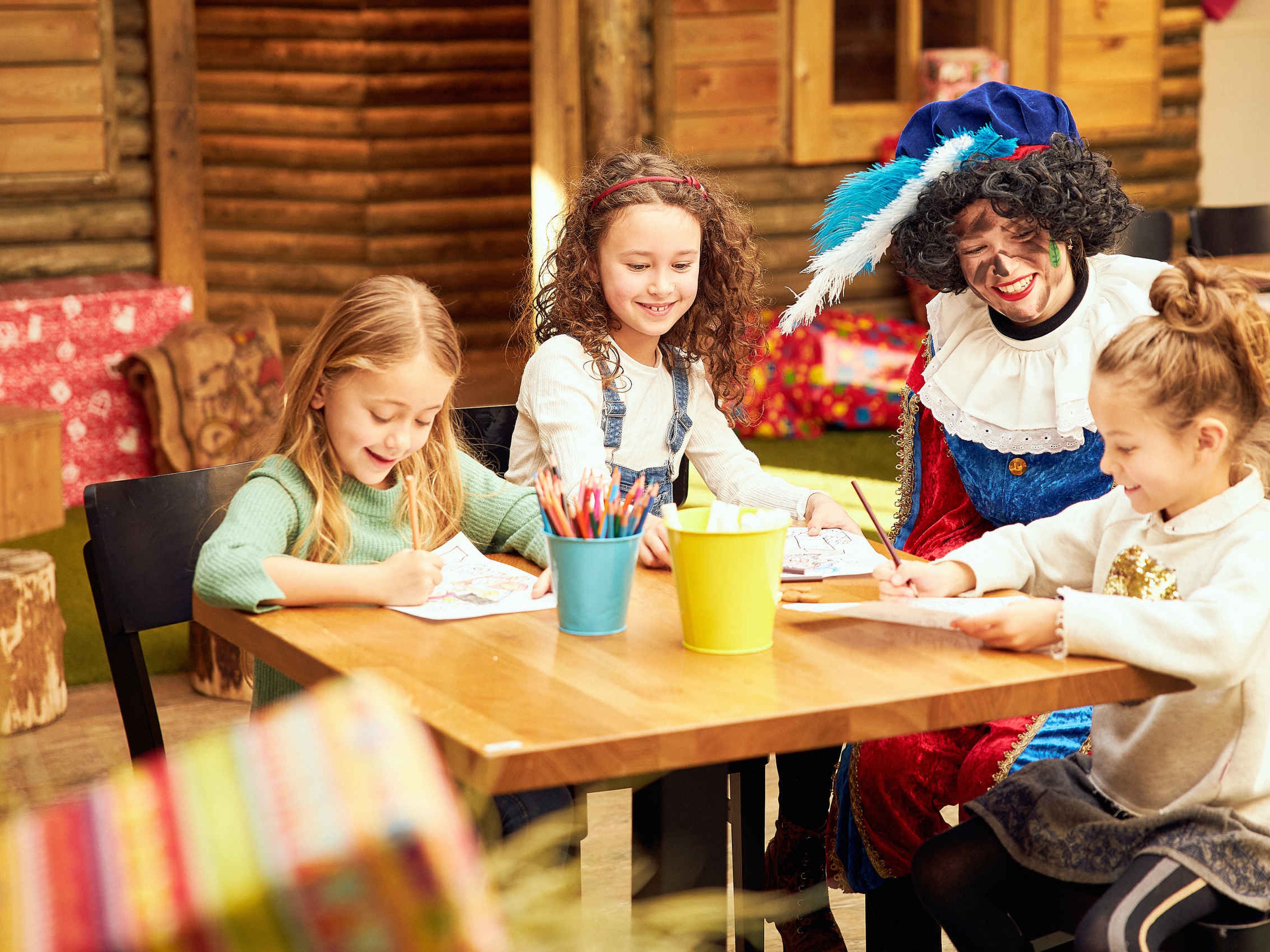 Kinderen tekenen samen met Piet tijdens Sinterklaas op Vakantiepark Dierenbos