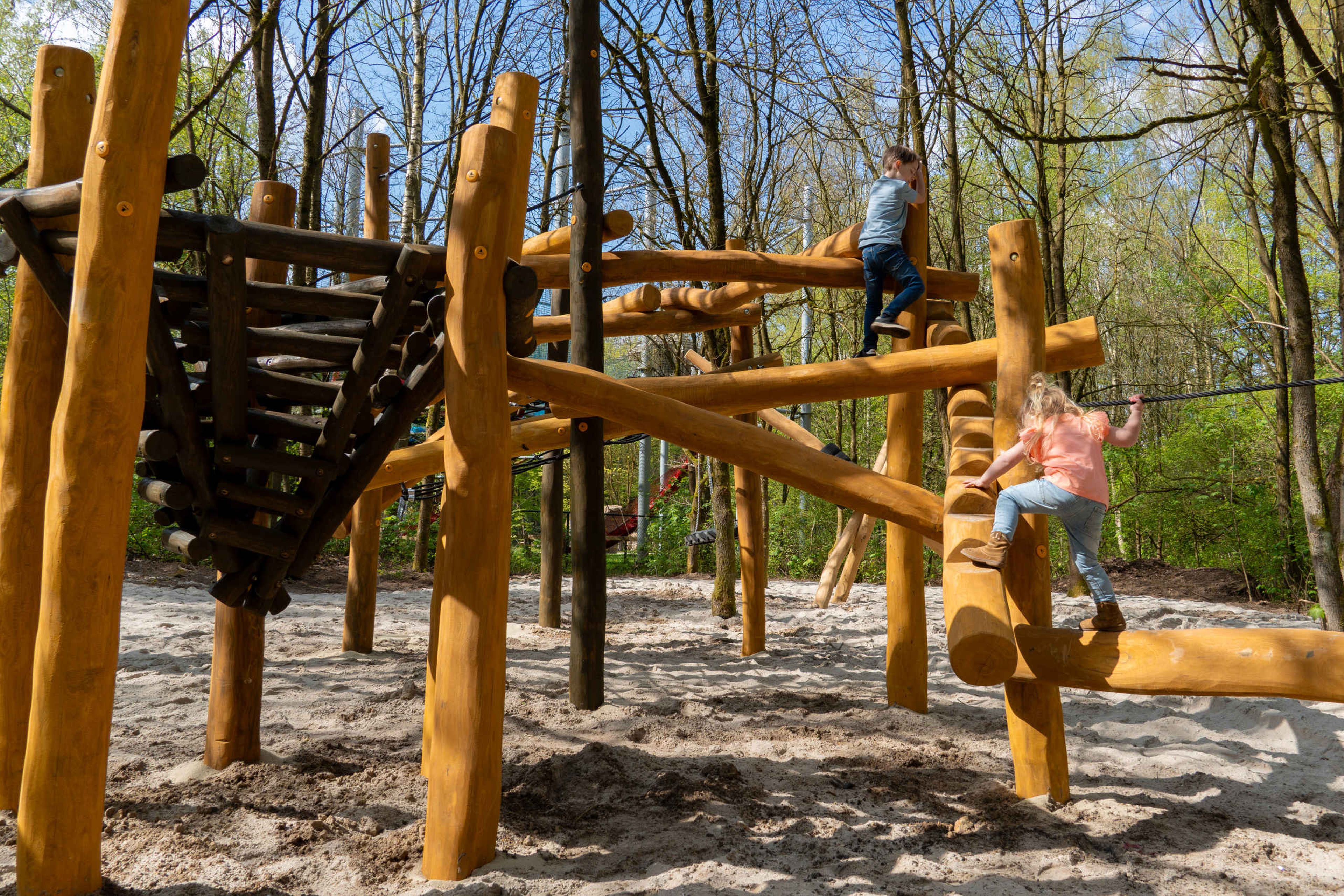 Twee kinderen klimmen op het klimrek in de speeltuin bij Klimrijk Brabant