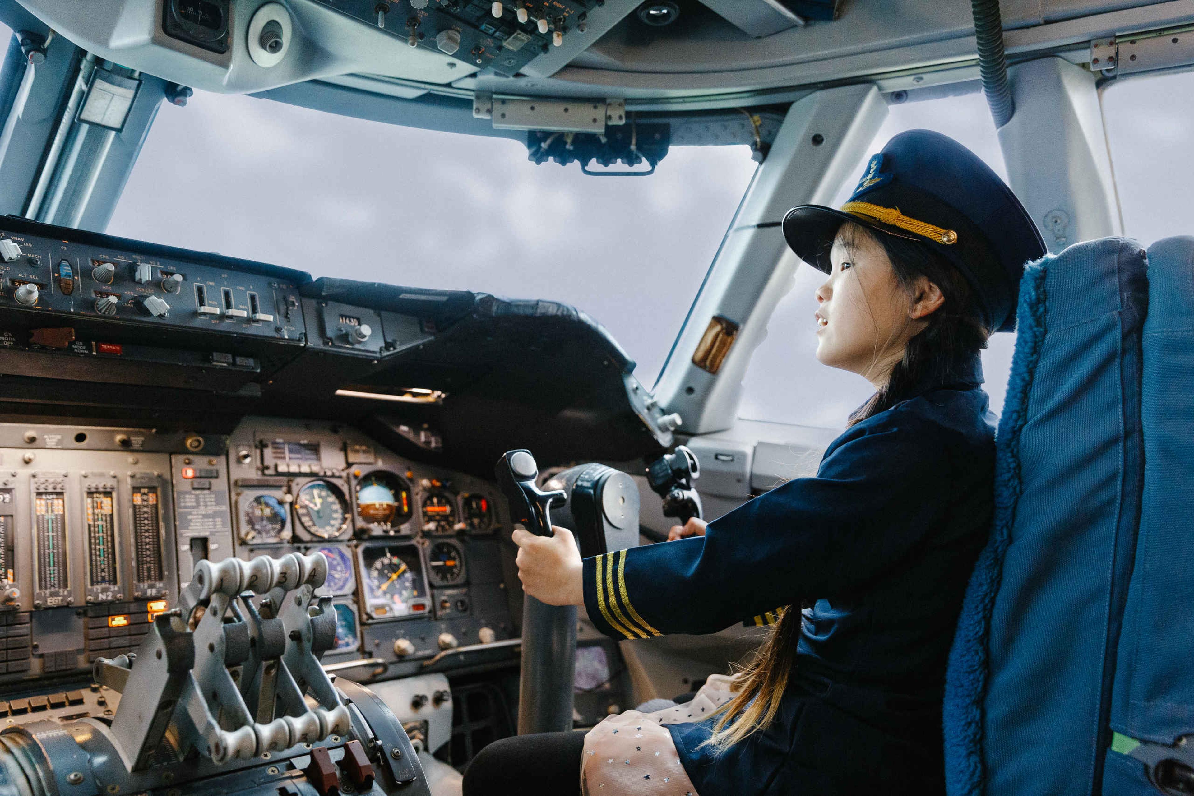 Een meisje zit in het vliegtuig bij luchtvaartmuseum Aviodrome.