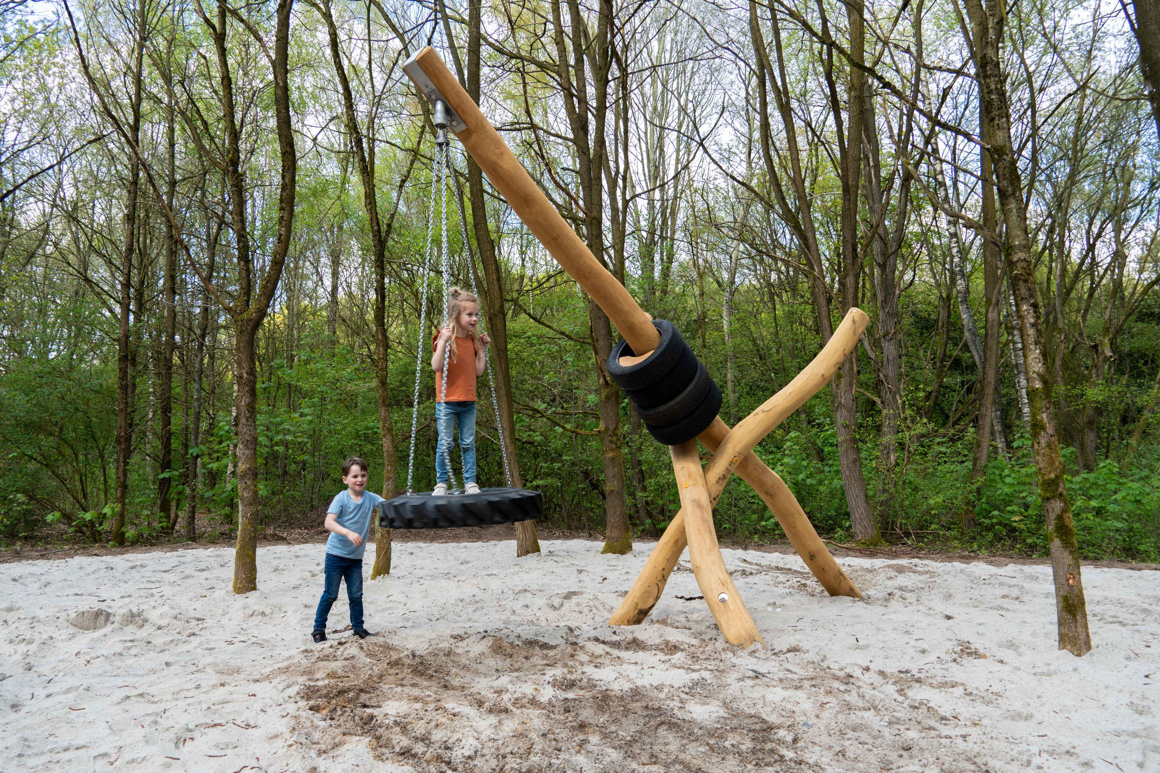 Kinderen spelen op de swingschommel in de speeltuin bij Klimrijk Brabant
