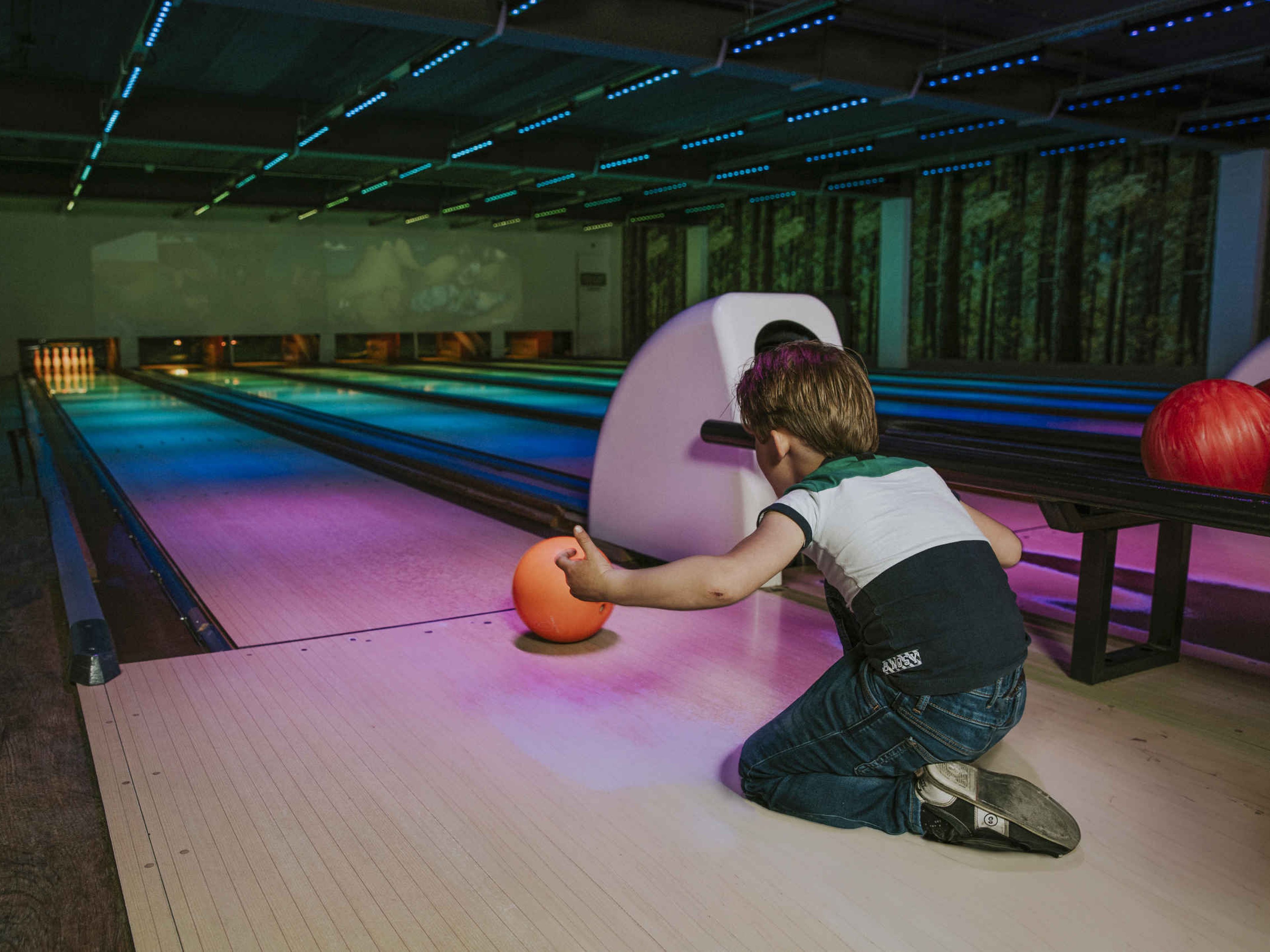 Jongen zittend aan het bowlen op de bowlingbaan bij Vakantiepark Dierenbos