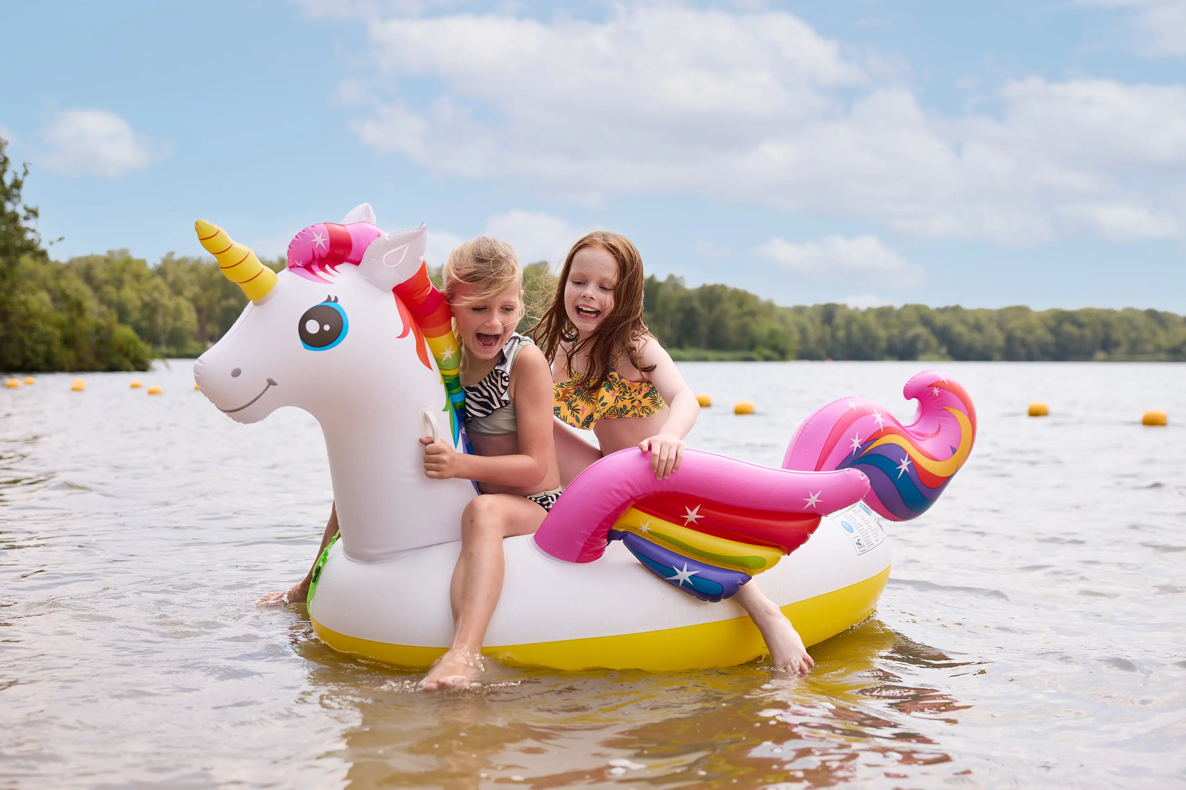 Kinderen met op opblaas eenhoorn aan het zwemmen bij Speelland Beekse Bergen