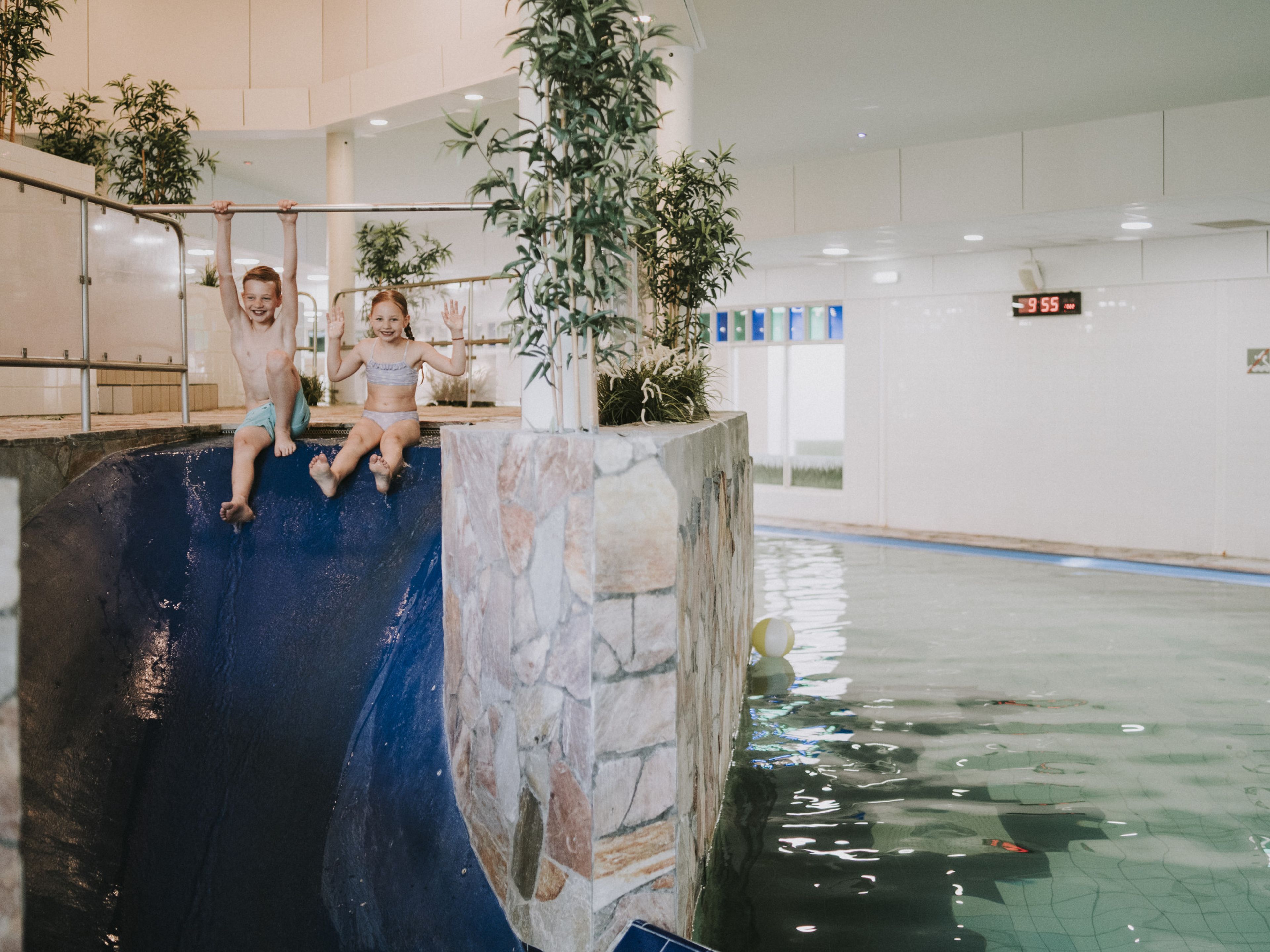 Kinderen glijden samen van de glijbaan in het zwembad van Vakantiepark Dierenbos