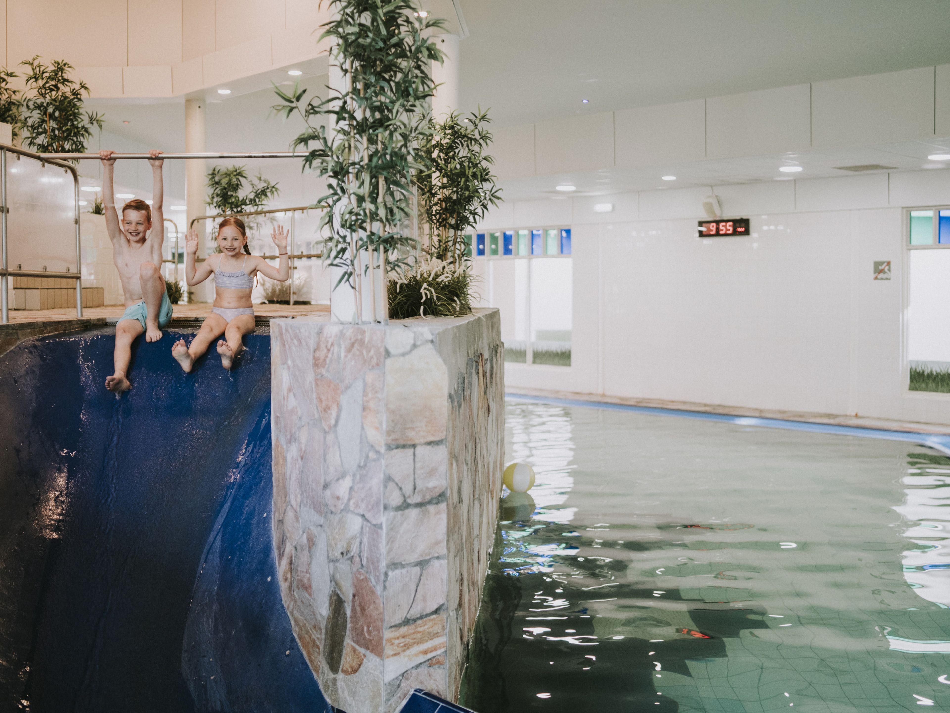 Kinderen glijden samen van de glijbaan in het zwembad van Vakantiepark Dierenbos