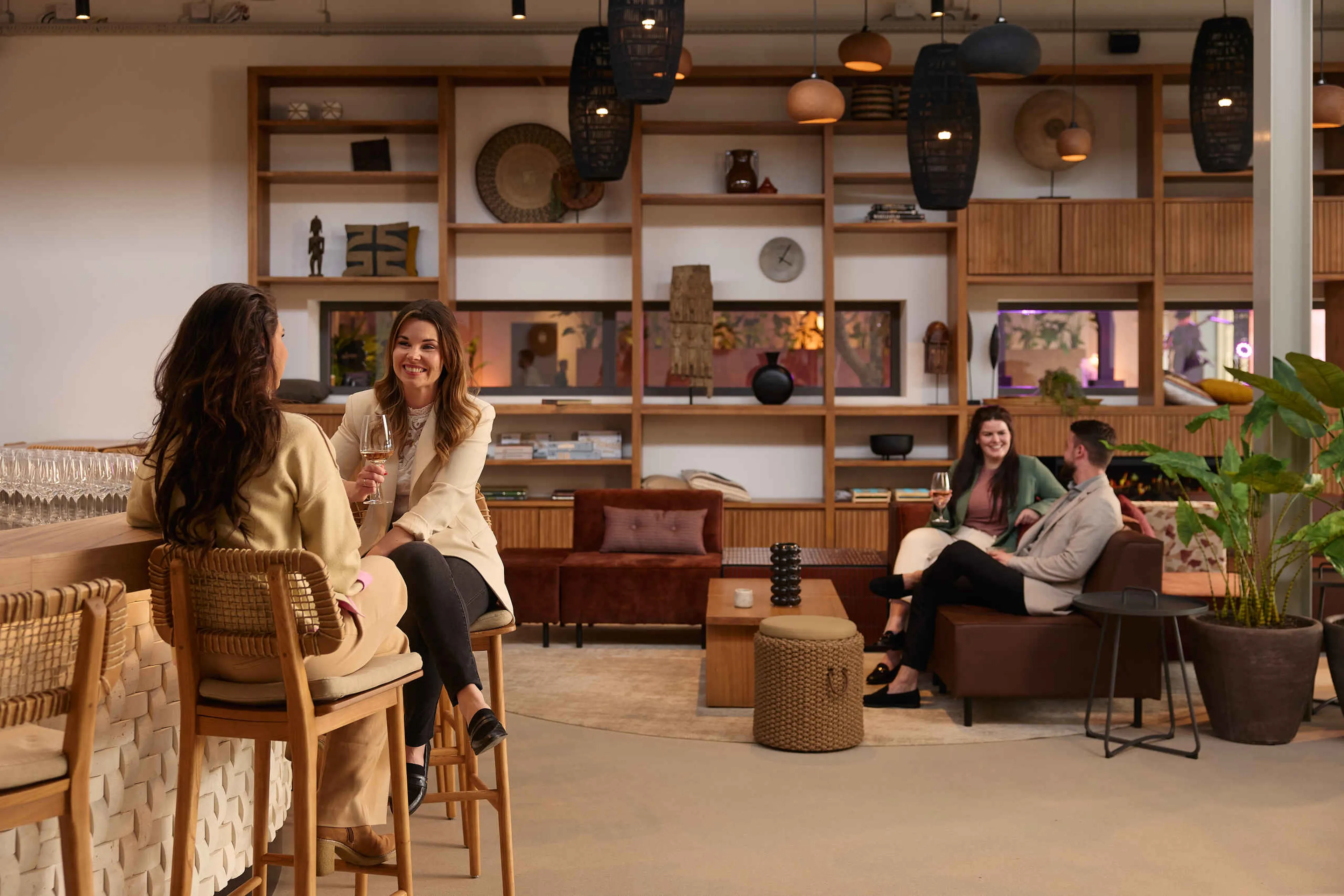 Twee stellen vrienden zitten in Hogon Bar & Lounge bij Safari Hotel Beekse Bergen.