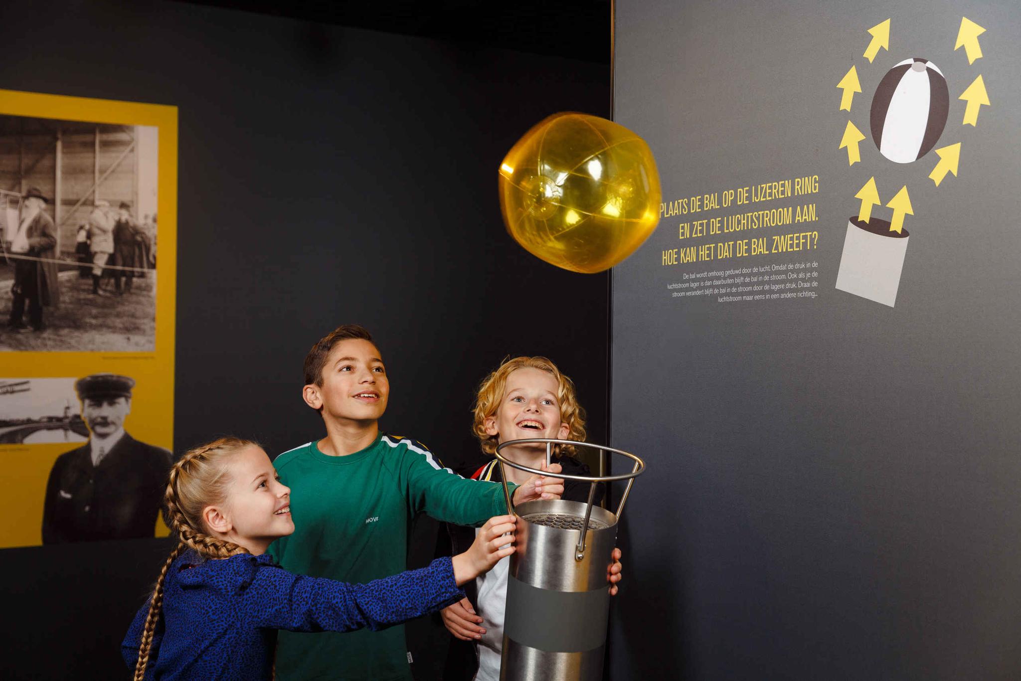 Kinderen spelen met het luchtkanon in de binnenexpositie van Luchtvaartmuseum Aviodrome