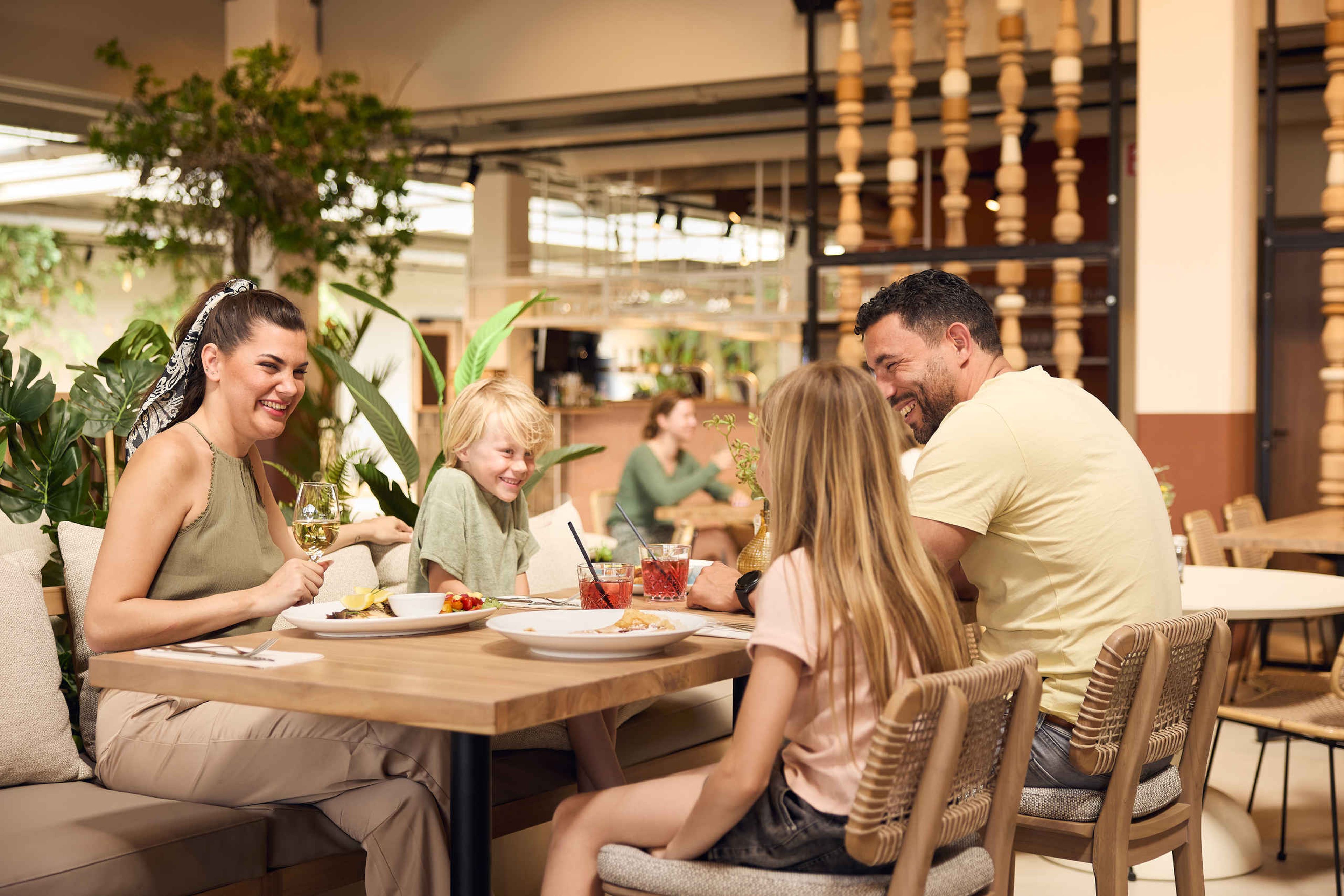Een gezin dineert bij restaurant Labadi in centrumgebouw Ganvi Village bij Beekse Bergen