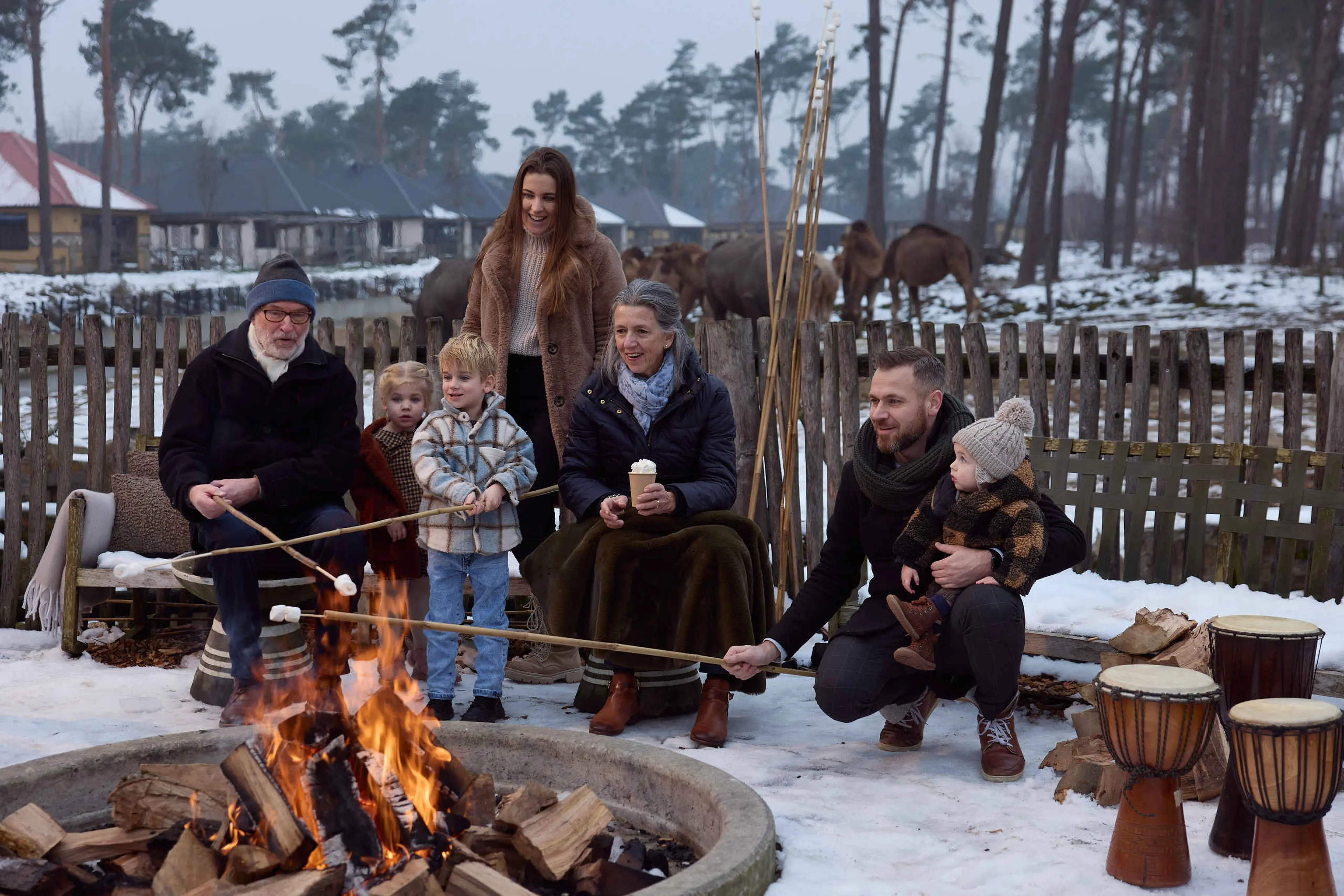 Winter een gezin bij een kampvuur in de sneeuw op Safari Resort Beekse Bergen