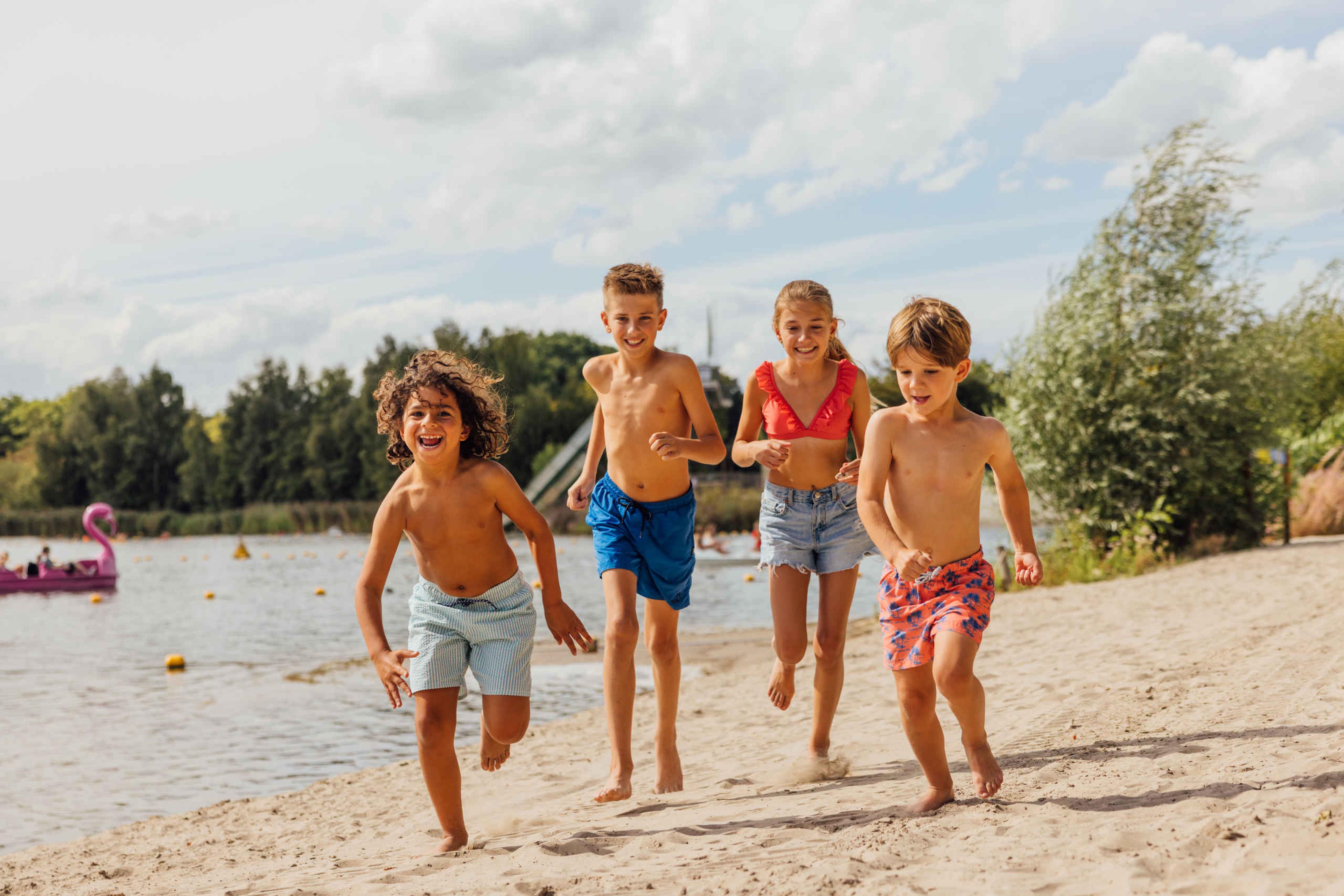 vier kinderen rennen op het strand bij Speelland Outdoor Beekse Bergen