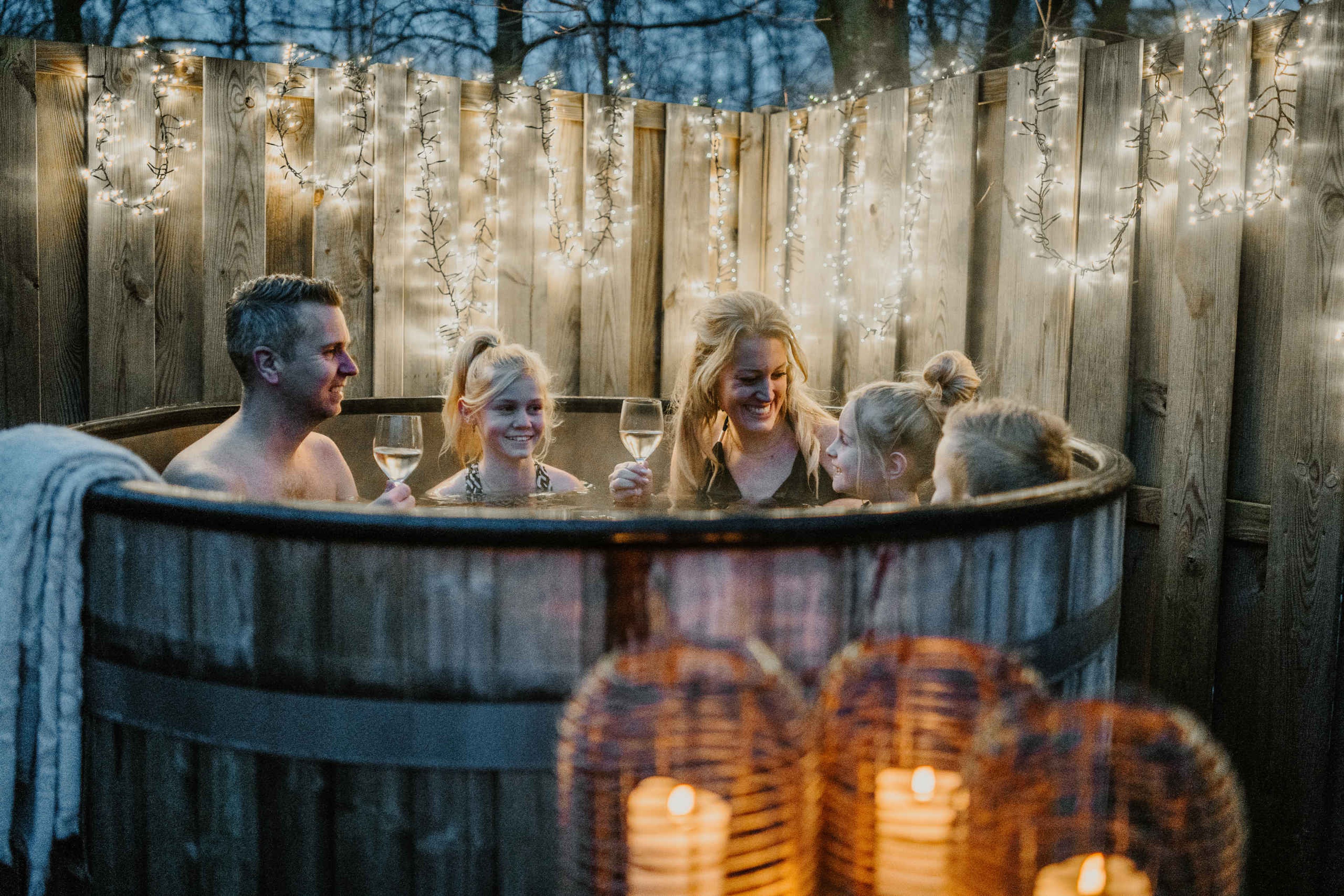 Een gezin zit in de winter in de hottub bij Vakantiepark Dierenbos.
