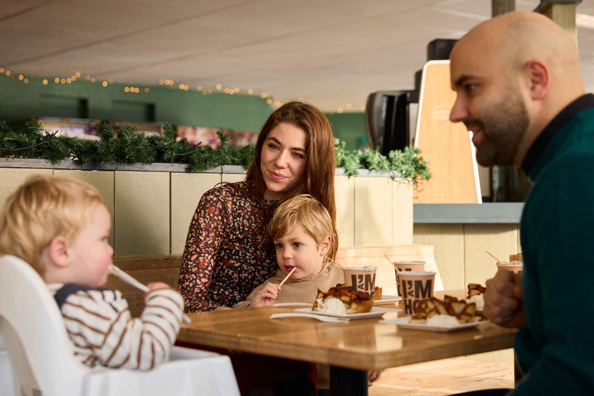 In de herfst een gezin met kinderen met chocomel en appeltaart in het restaurant van AquaZoo Leeuwarden