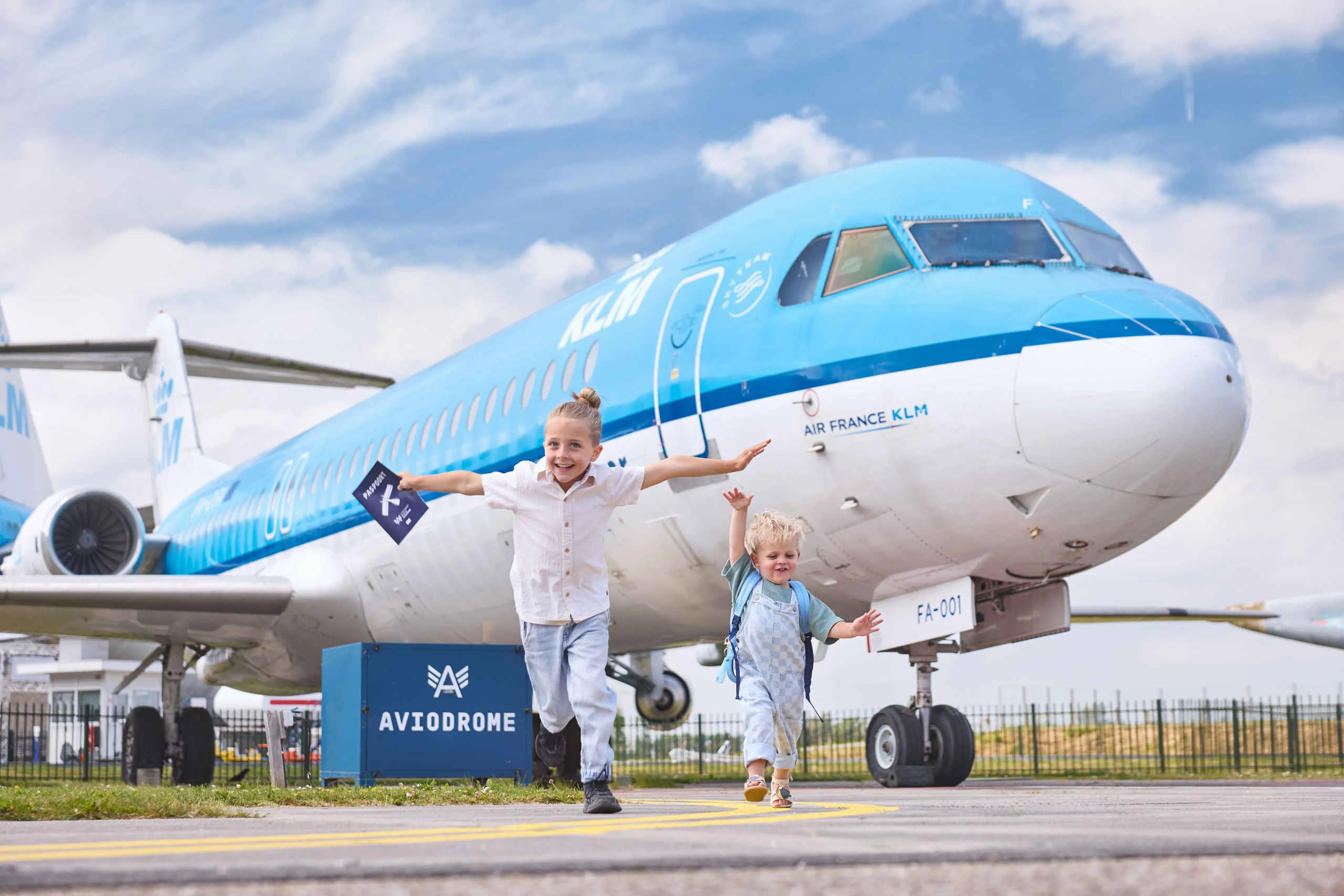 Kinderen rennen voor KLM fokker 100 in Luchtvaartmuseum Aviodrome