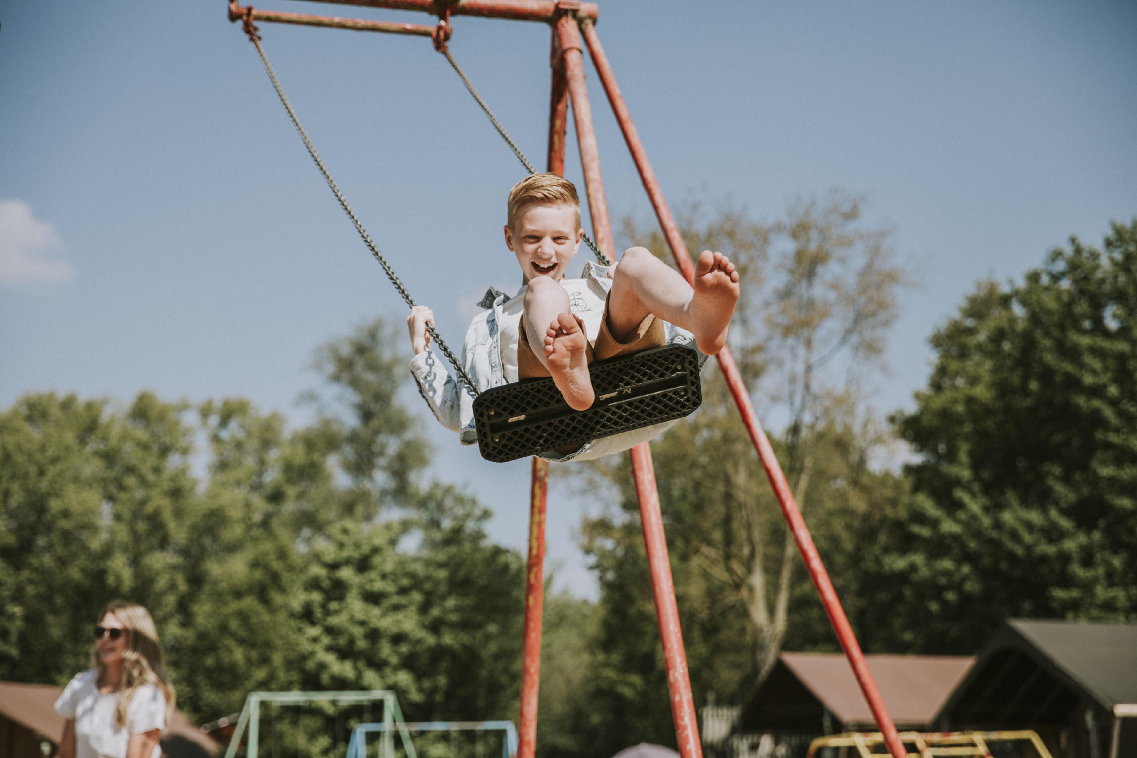 Jongen op schommel in de speeltuin van Vakantiepark Dierenbos