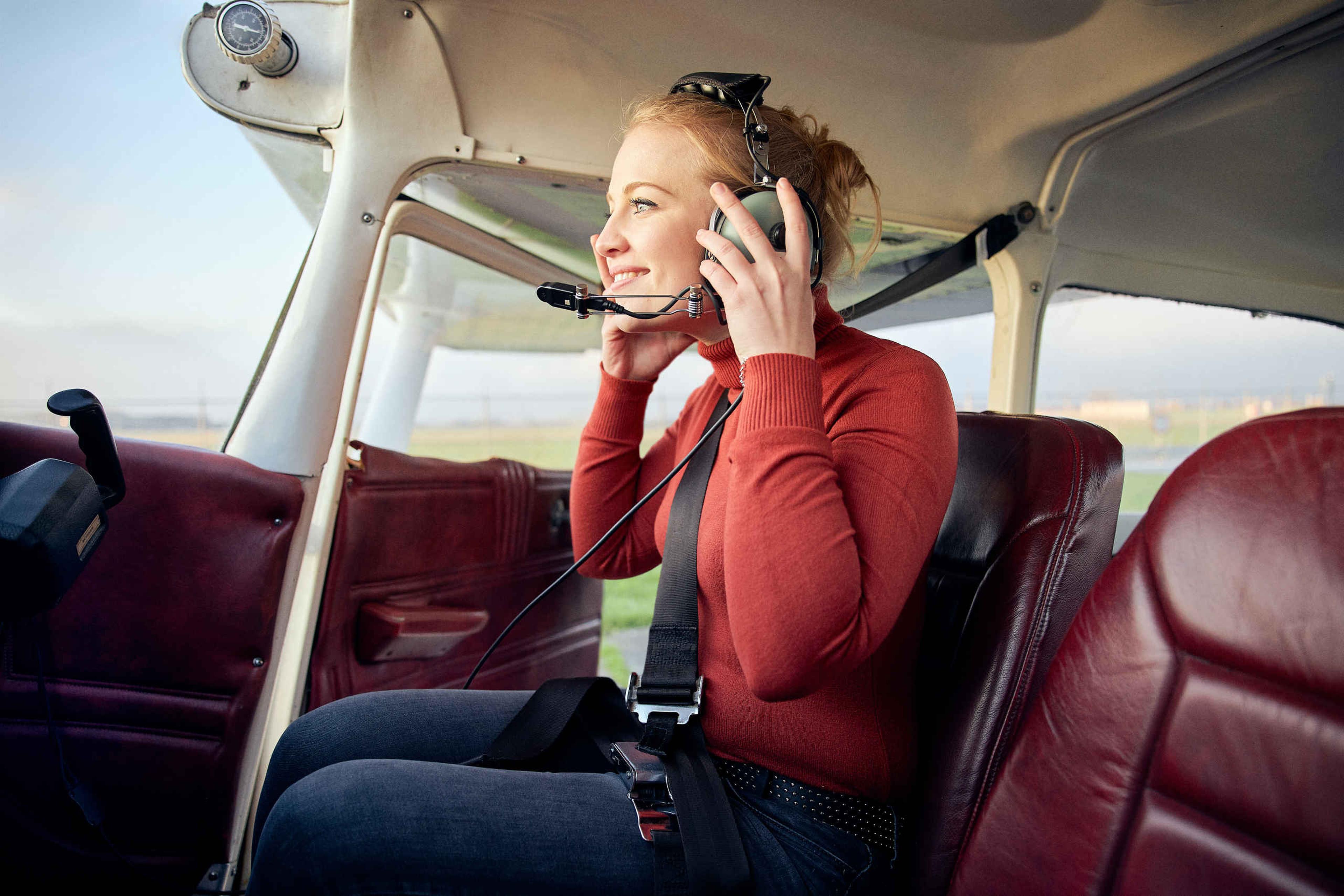 Een vrouw in de cockpit van een vliegtuig, klaar voor een rondvlucht als zakelijk activiteit bij Aviodrome.