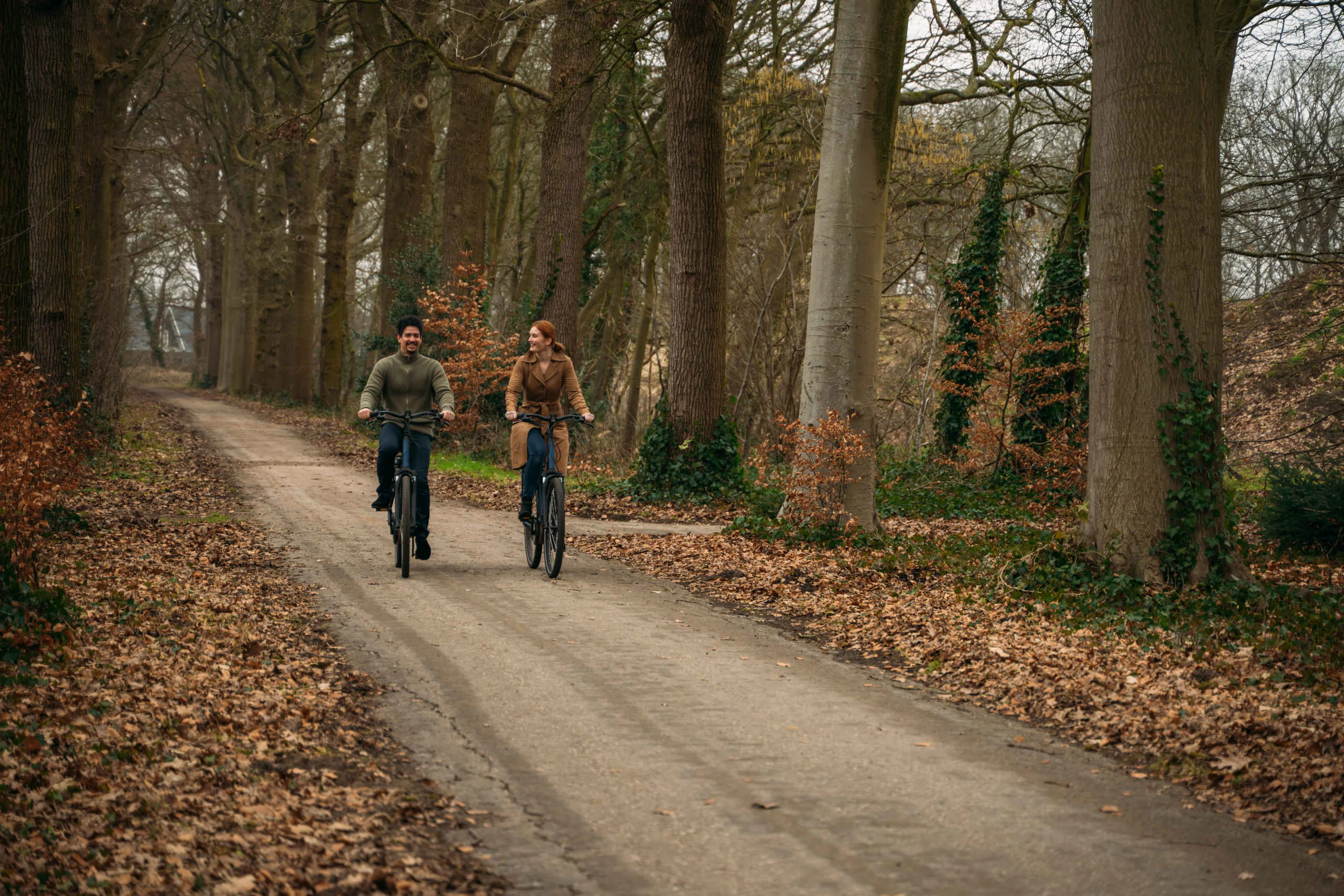 Stel bestaande uit een man en vrouw fietsen in de herfst bij Kasteel Steenenburg