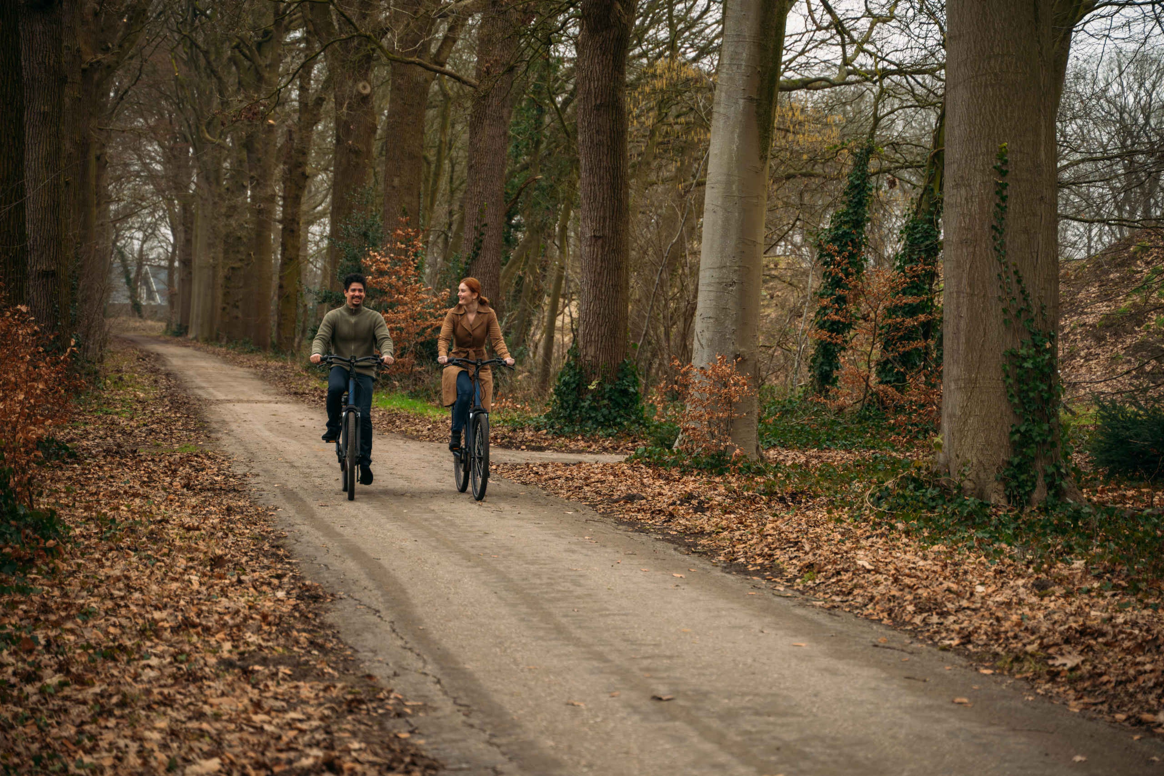 Stel bestaande uit een man en vrouw fietsen in de herfst bij Kasteel Steenenburg