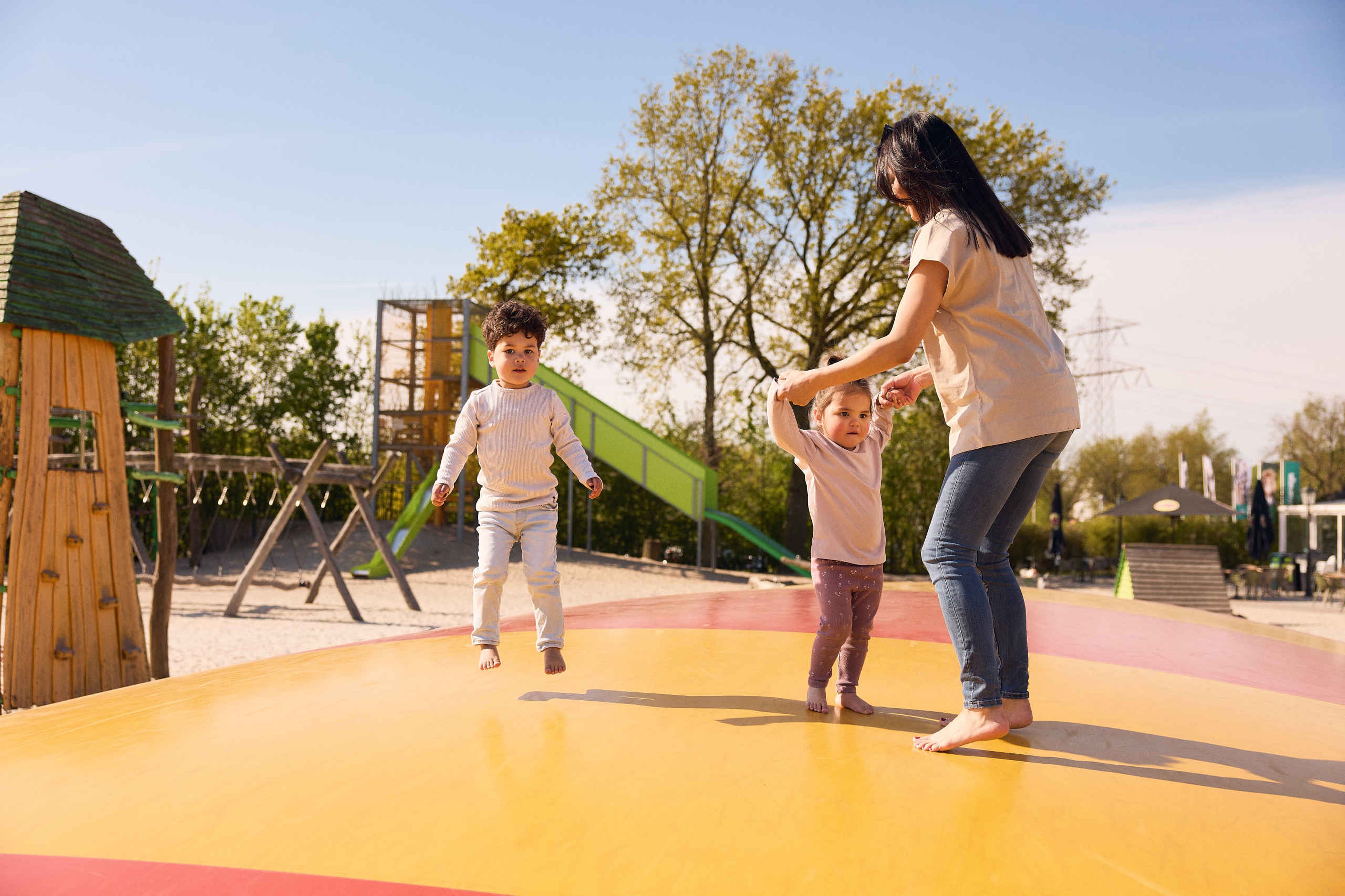 Een vrouw en haar kinderen springen op de airtrampoline in de speeltuin in Eindhoven Zoo.