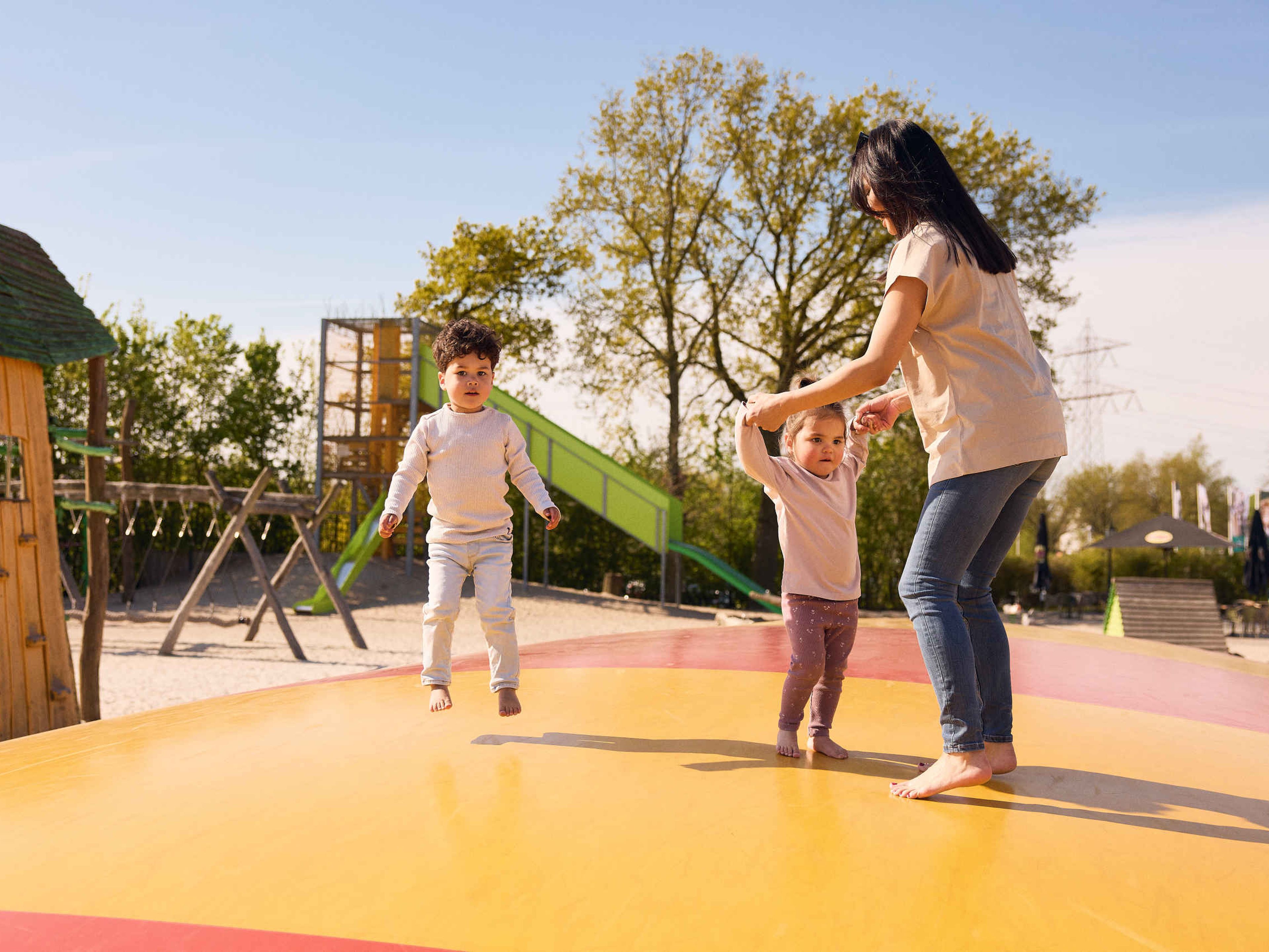 Een vrouw en haar kinderen springen op de airtrampoline in de speeltuin in Eindhoven Zoo.