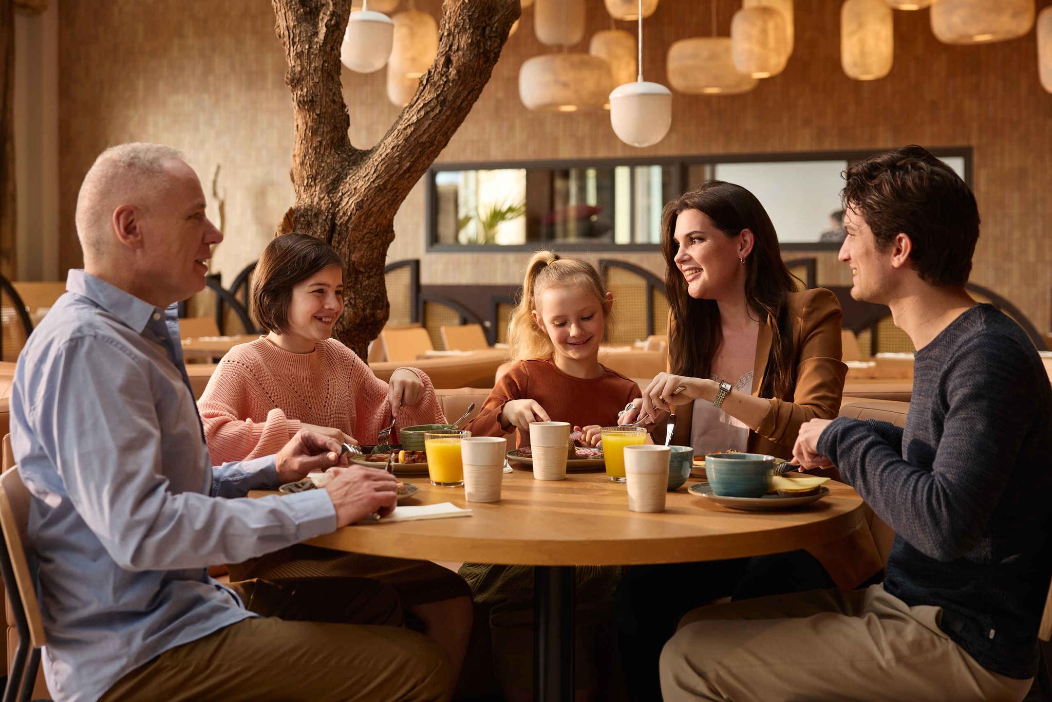 Een gezin geniet van het ontbijtbuffet van buffet en live cooking restaurant Amma in Safari Hotel Beekse Bergen.