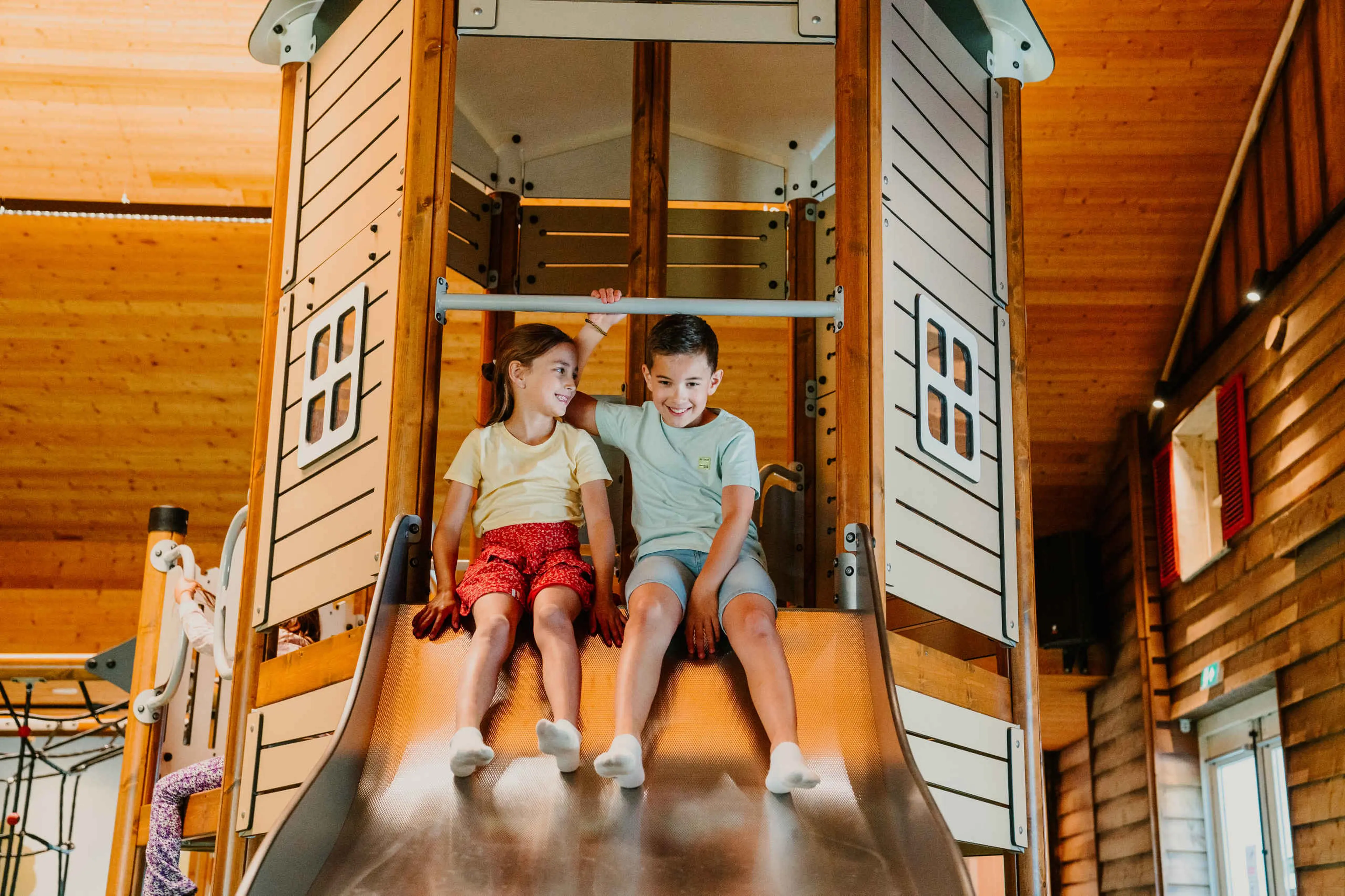 Twee kinderen glijden van de glijbaan bij Vakantiepark Dierenbos.